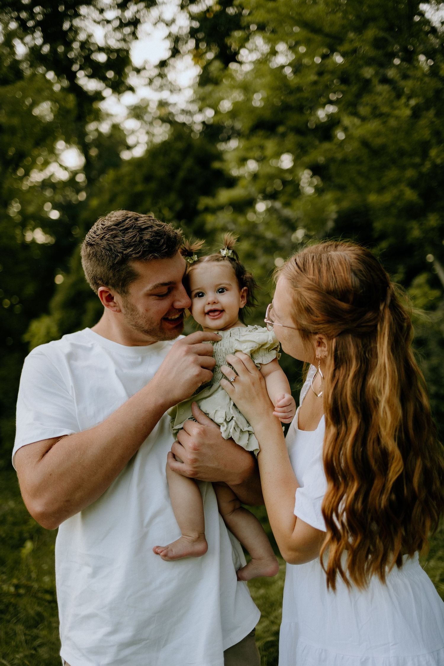 Young family sharing a joyful moment outdoors in summer greenery.