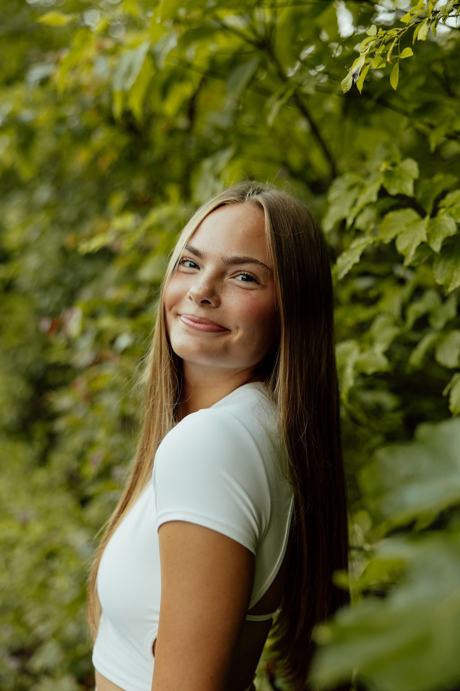 Portrait series of a person in a white t-shirt against green foliage background showing different expressions and poses.