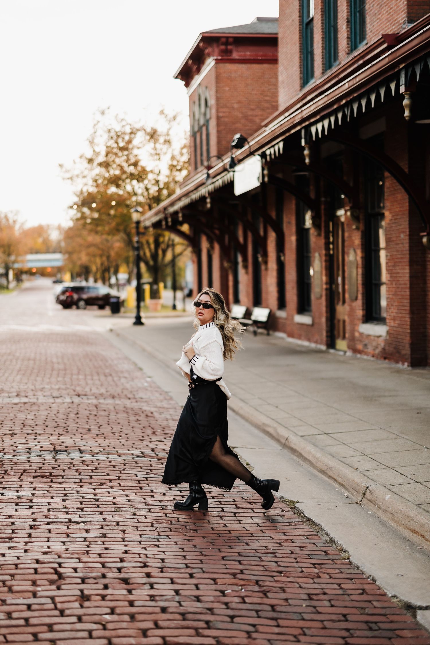 A stylish vintage-inspired outfit photographed on a historic brick street.