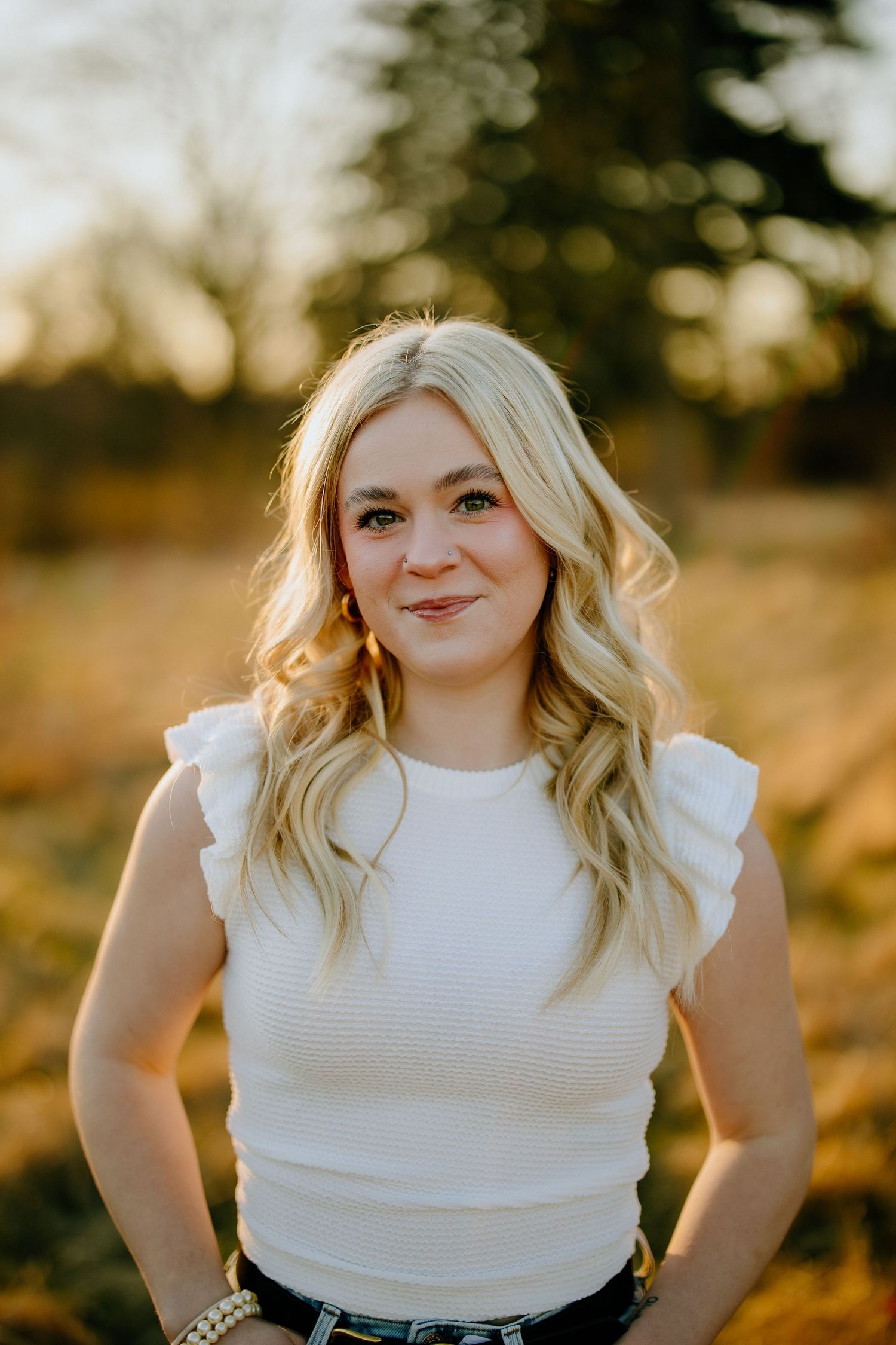 Outdoor portrait in golden hour lighting wearing a white ruffle sleeve top.