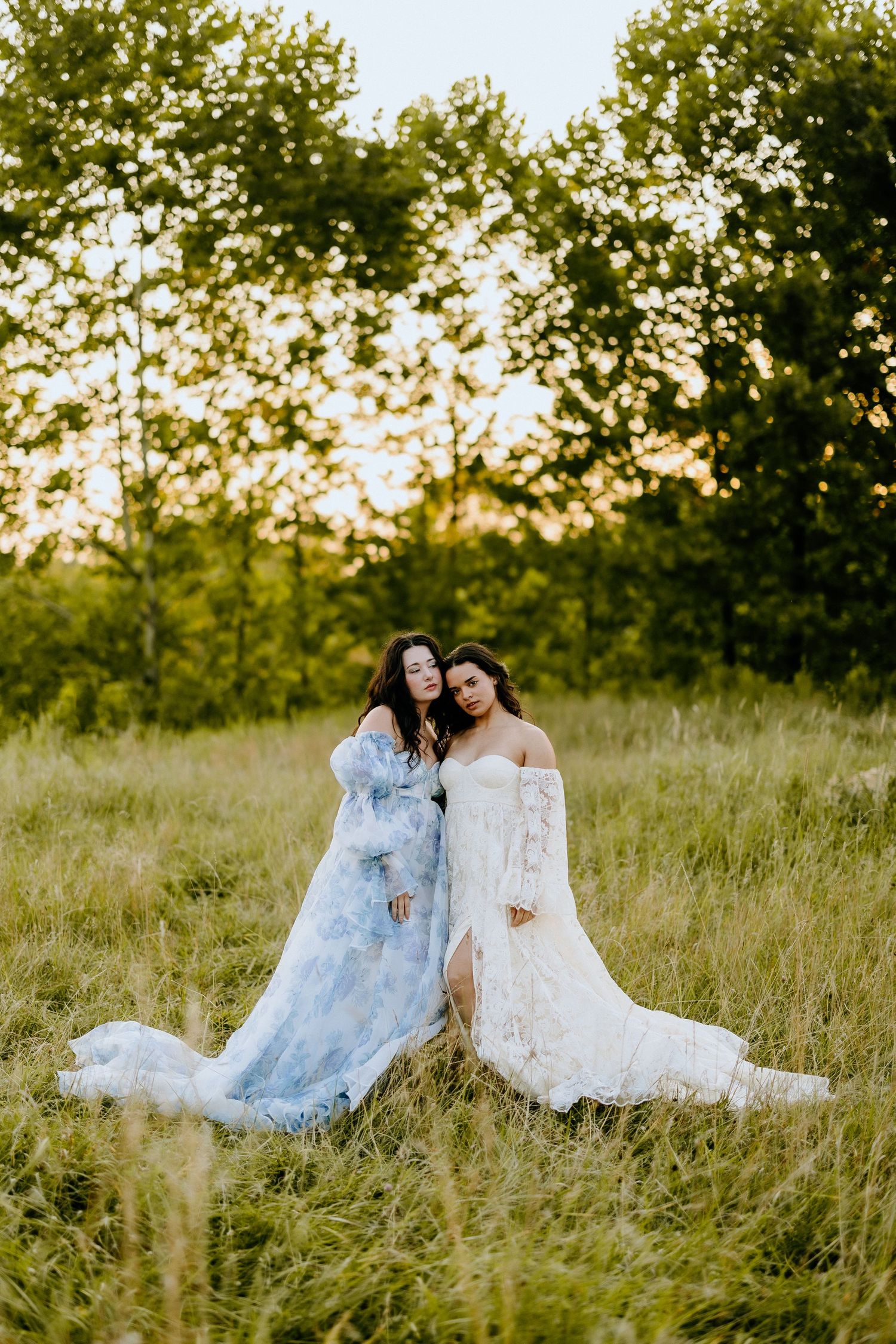 Two flowing dresses in blue and white create dreamy scene in summer field.