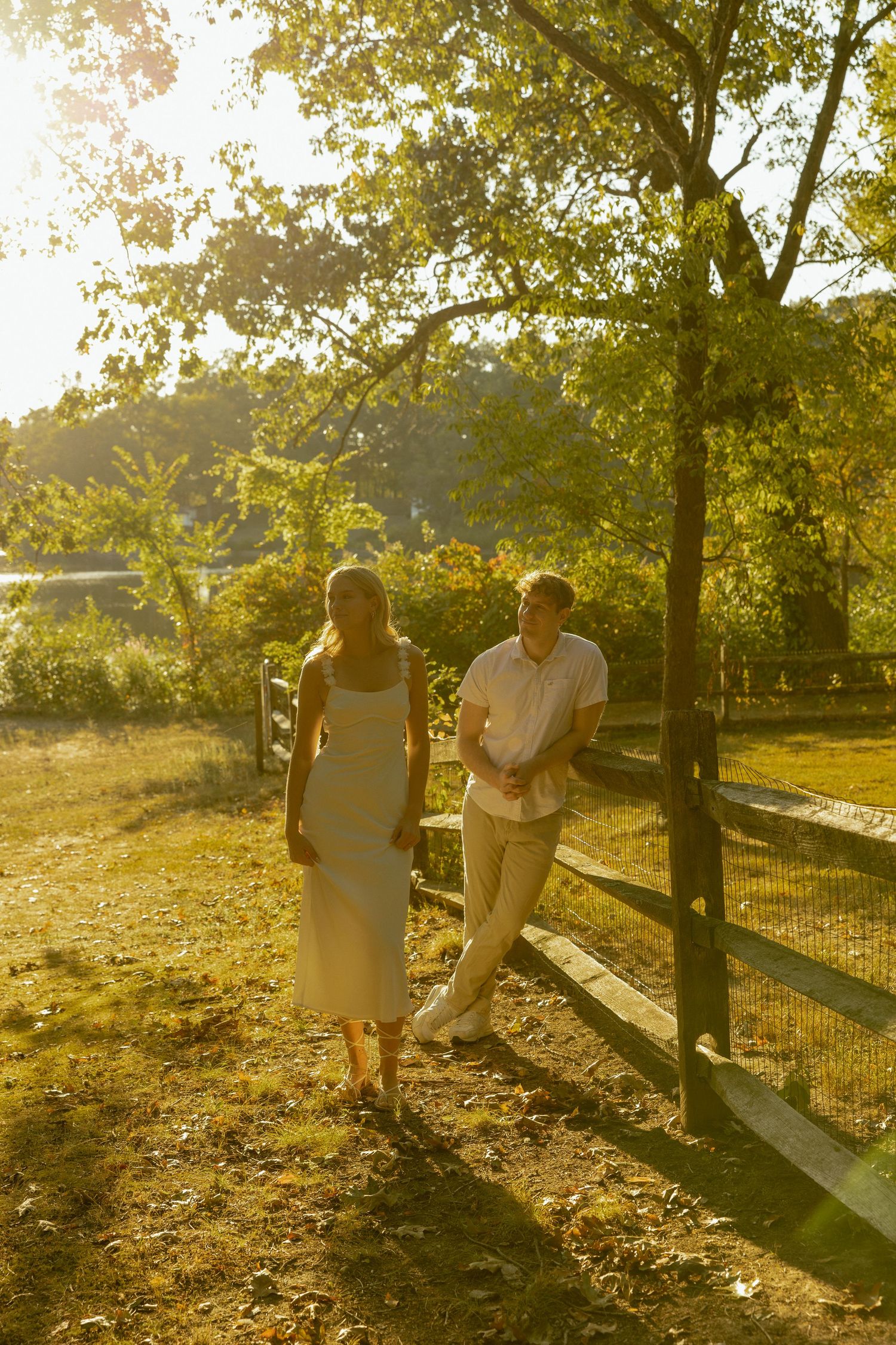Couple enjoying a romantic sunset moment in a park with golden light filtering through autumn trees.