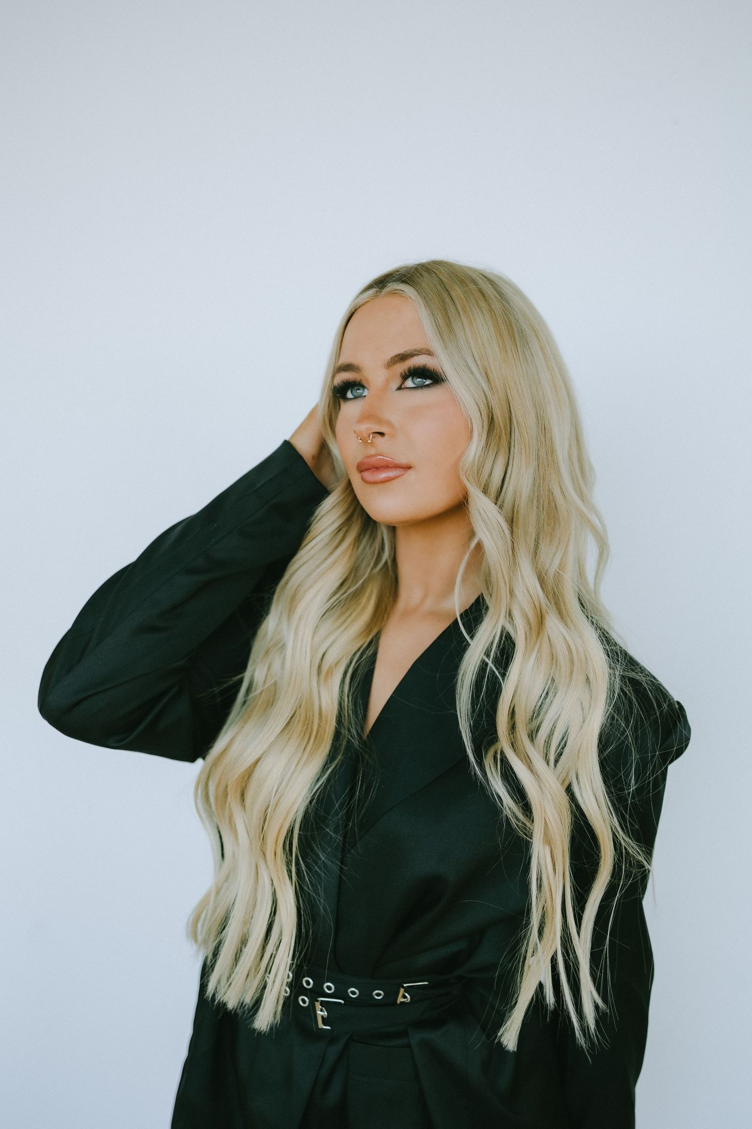 Stylish fashion photo featuring black outfit, wavy blonde hair and sophisticated makeup.