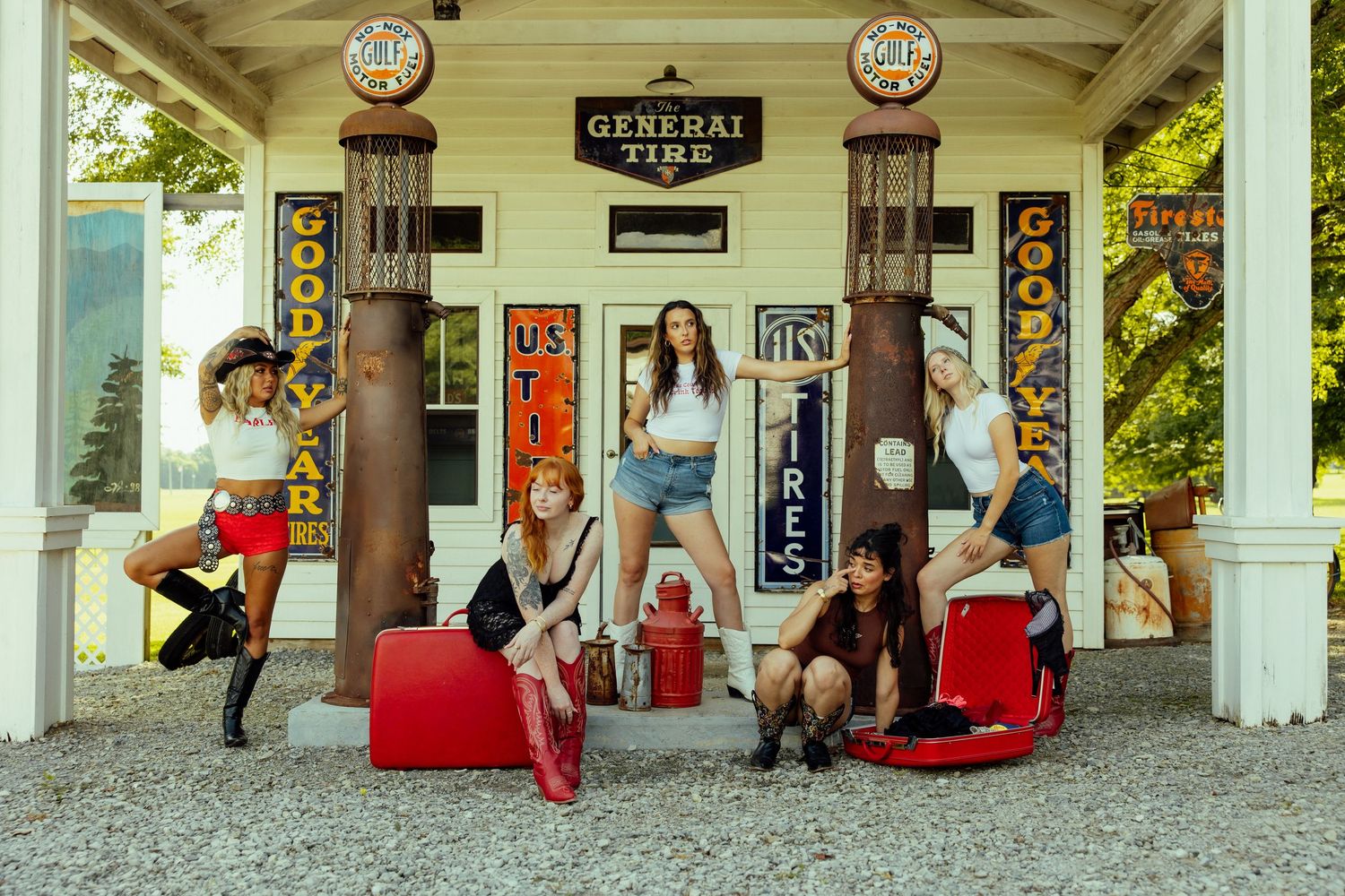 People relax and socialize in rocking chairs on a covered porch at a country store.