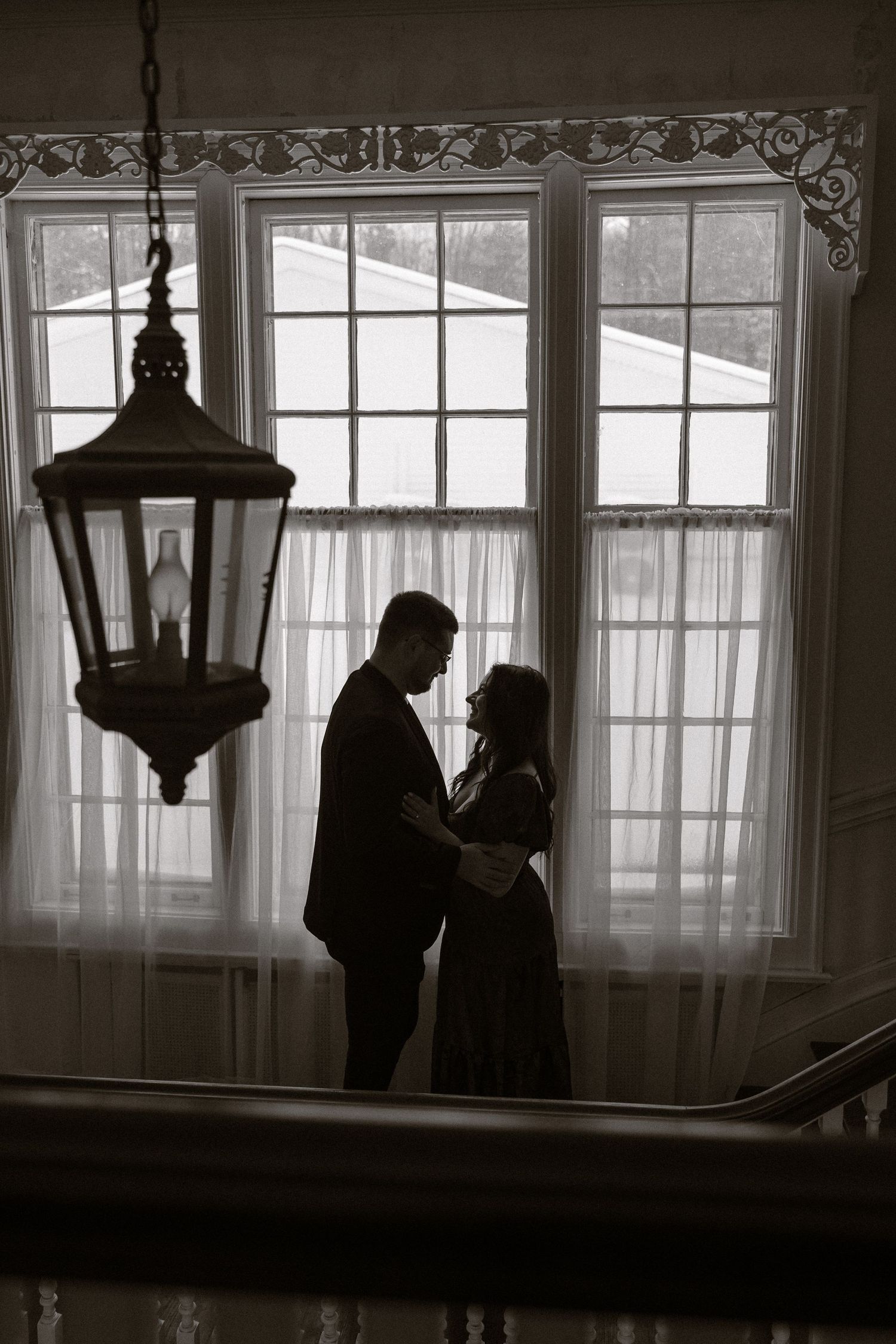 Silhouetted figures stand in front of bright windows in a moody black and white photographic sequence.