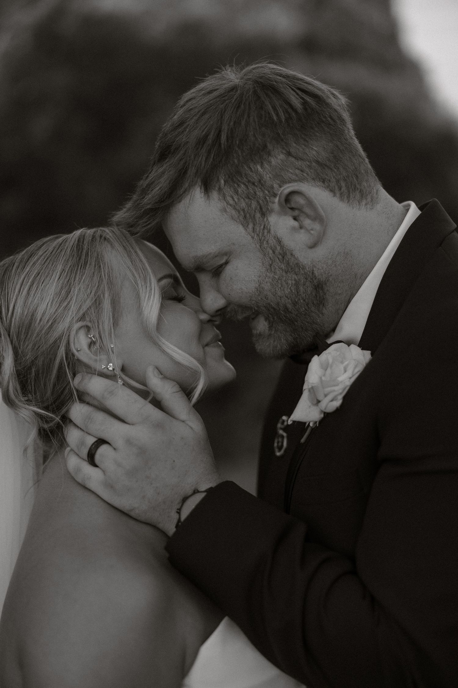 A series of romantic black and white wedding photos showing tender kisses between a couple.