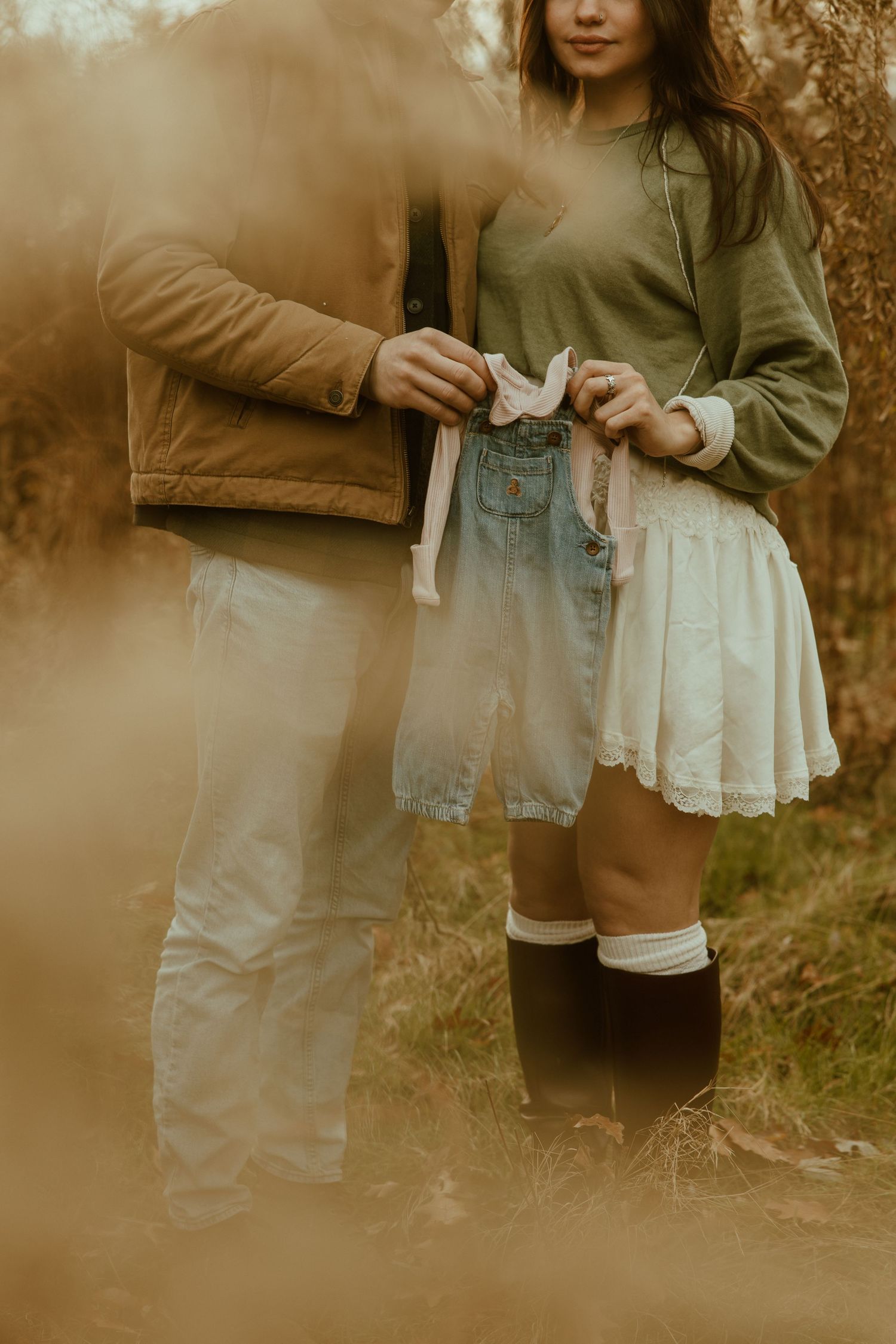 Couple holding hands outdoors in autumn wearing casual clothing with knee-high socks and flowy skirt.