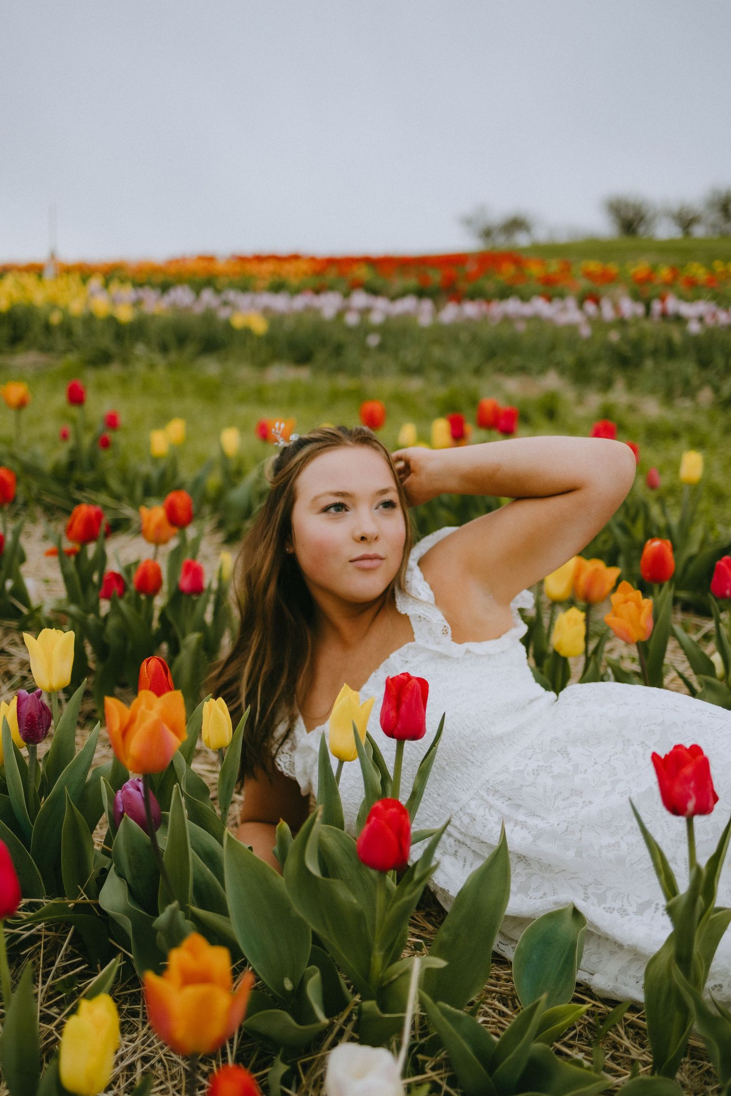 Artistic portrait shot among colorful spring tulips in a garden field.