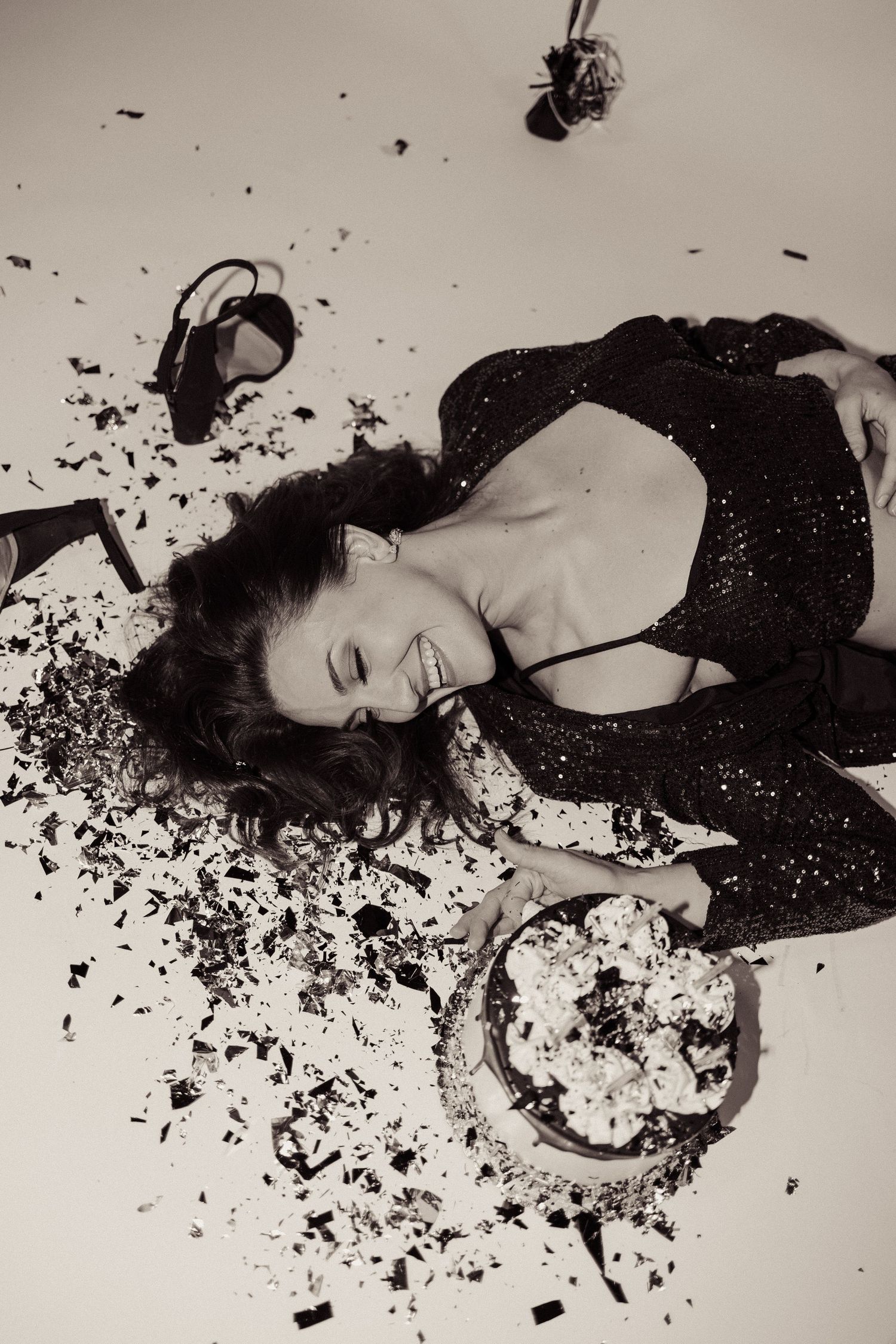Black and white photo of joyful cake smash with scattered dessert.