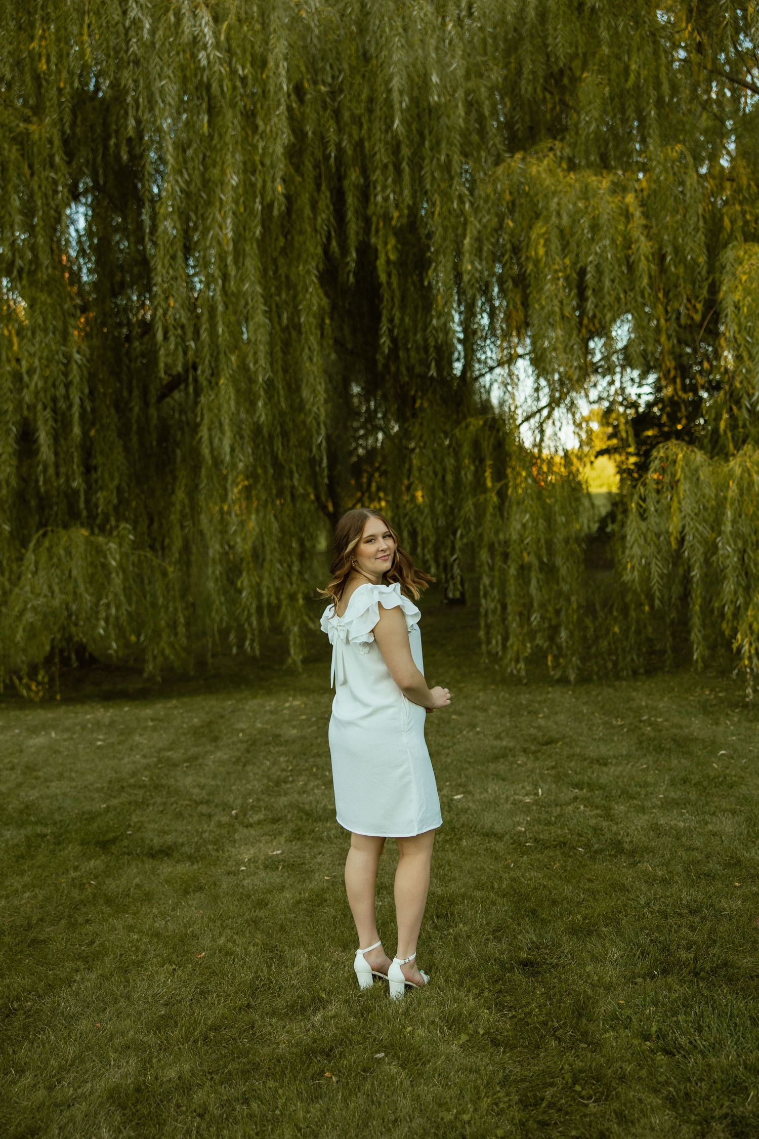 A series of photos showing someone walking through a lush garden with drooping willow trees in the background.