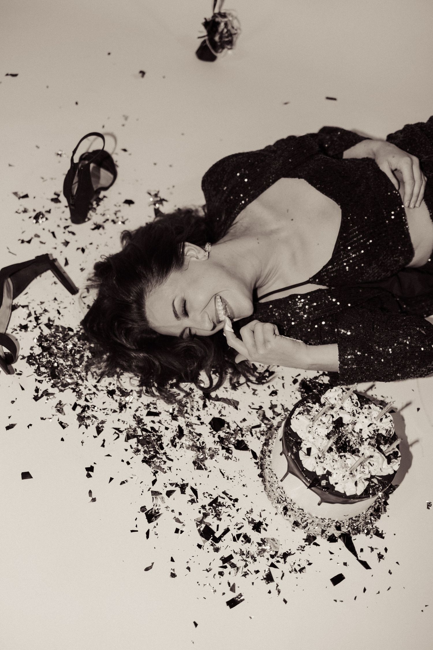 Artistic black and white portrait with destroyed cake and balloons.