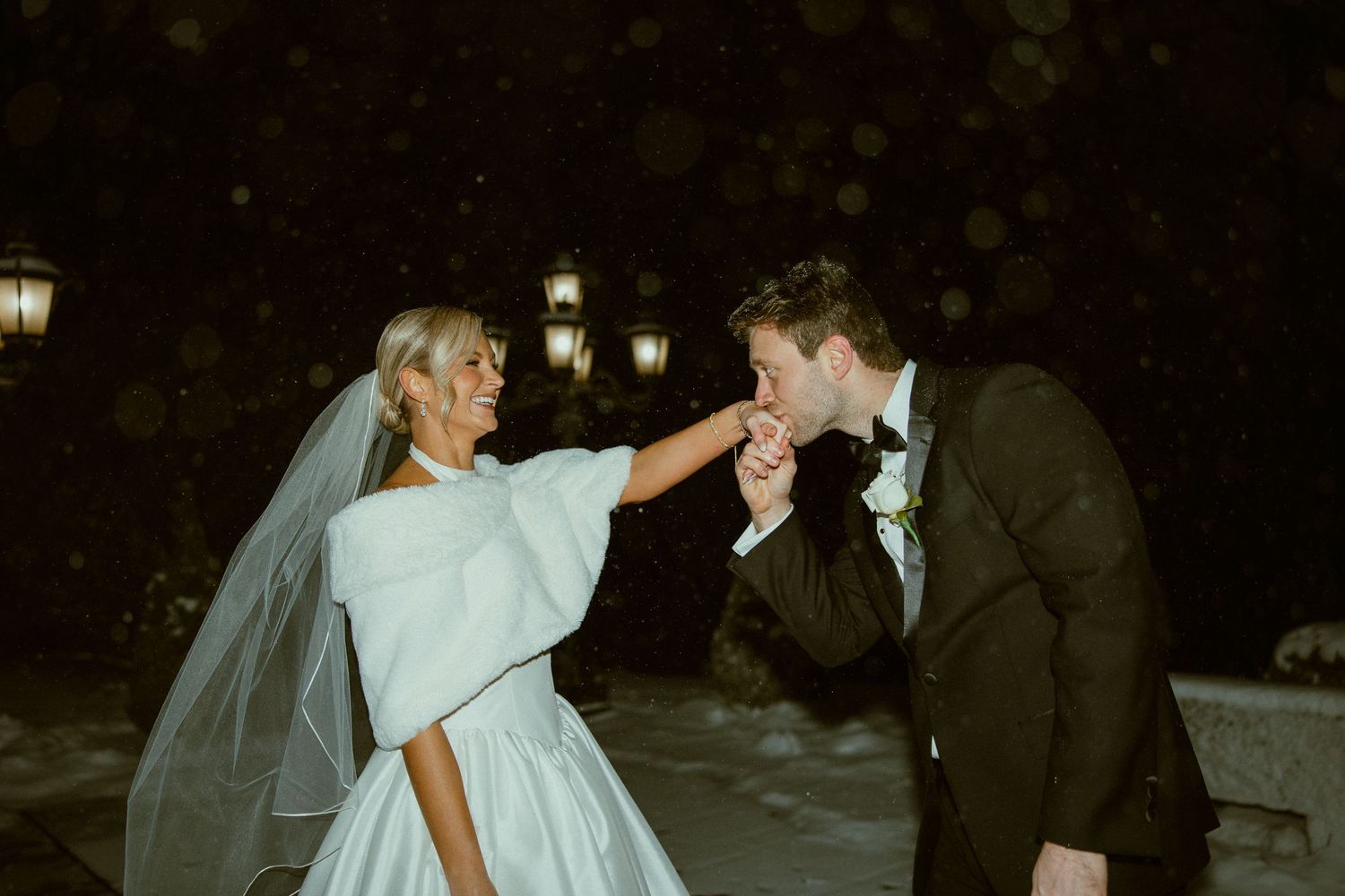 Wedding celebration at night with guests and decorative outdoor lighting creating a festive atmosphere.