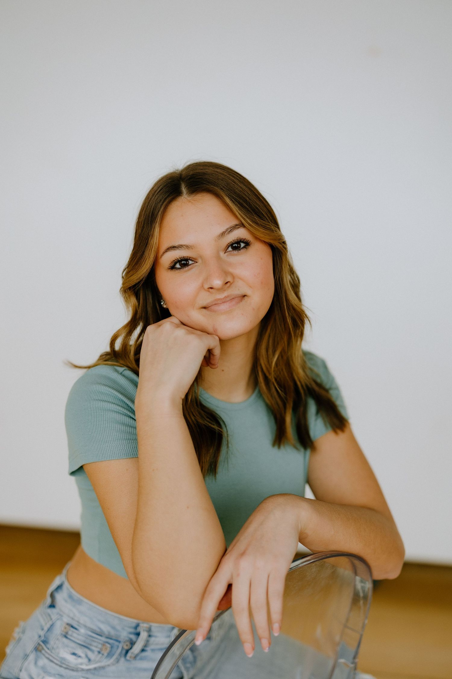Casual portrait in soft lighting with mint green crop top and denim.