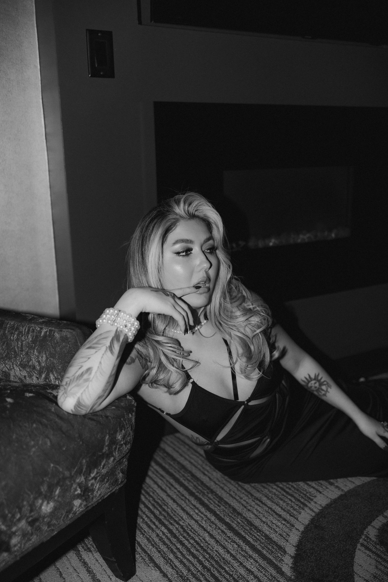 Moody black and white portrait showing lingerie and vintage furniture.