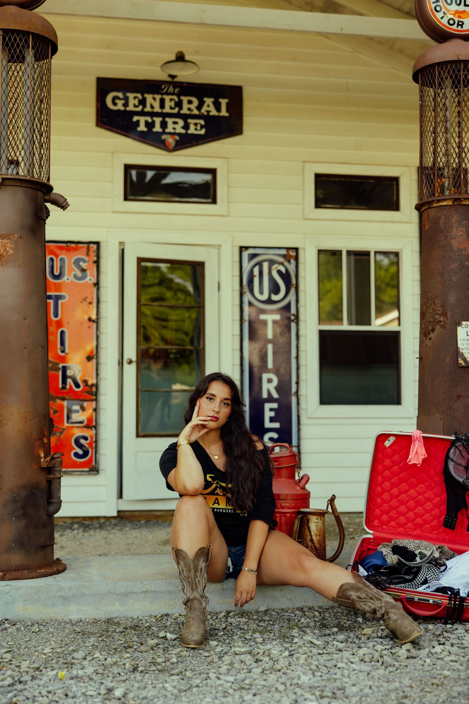 Vintage gas station storefront with General Tire signage and rustic wooden columns on gravel lot.