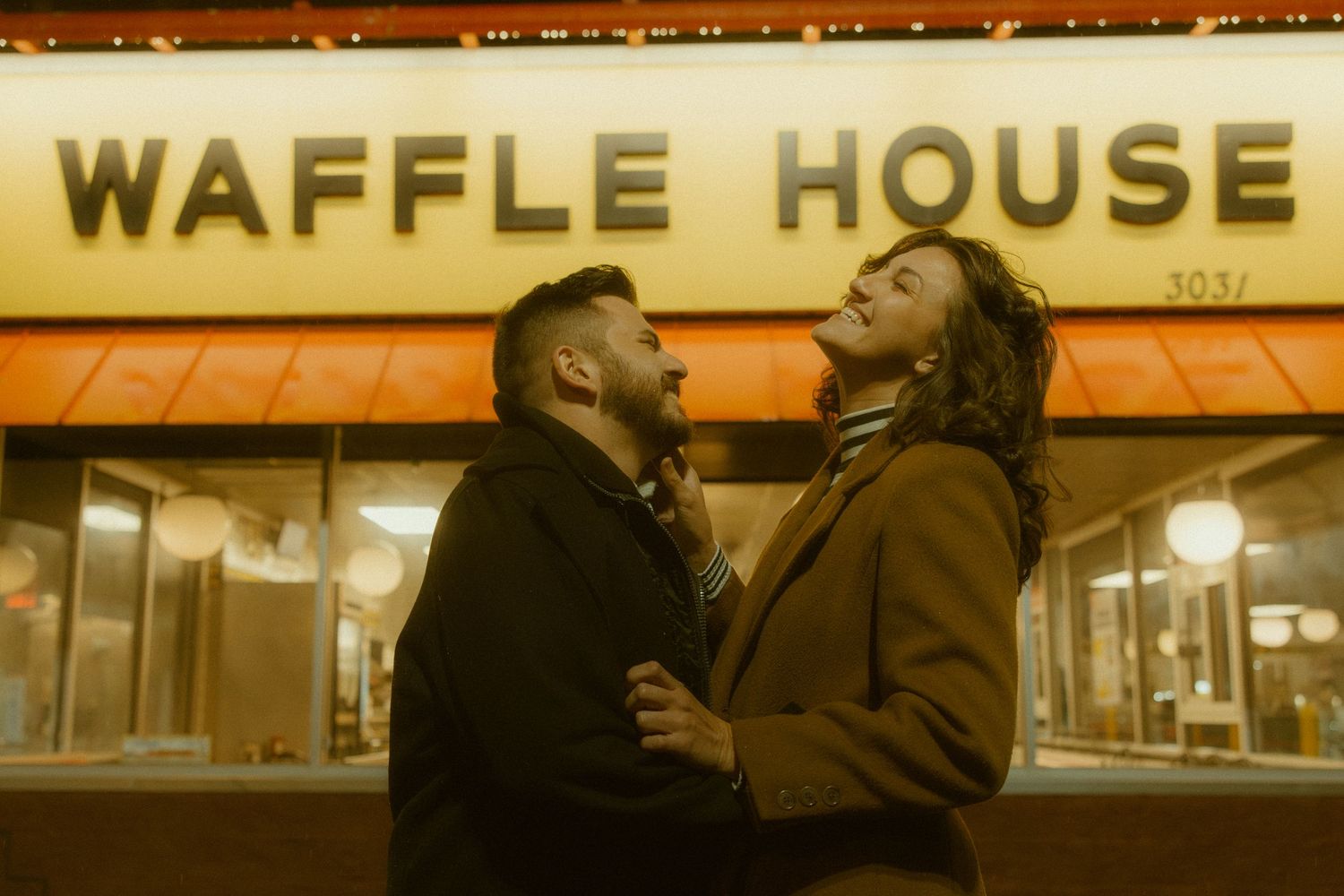 A glowing yellow Waffle House sign illuminates the exterior of the restaurant at night.