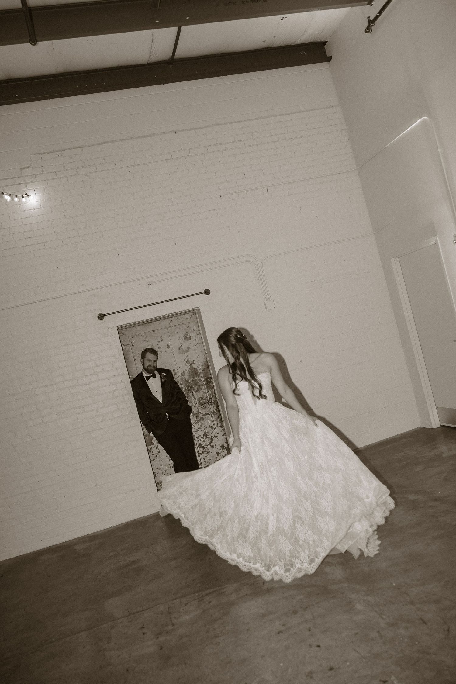 Sequential black and white photos capturing movement across an industrial room with white brick walls.