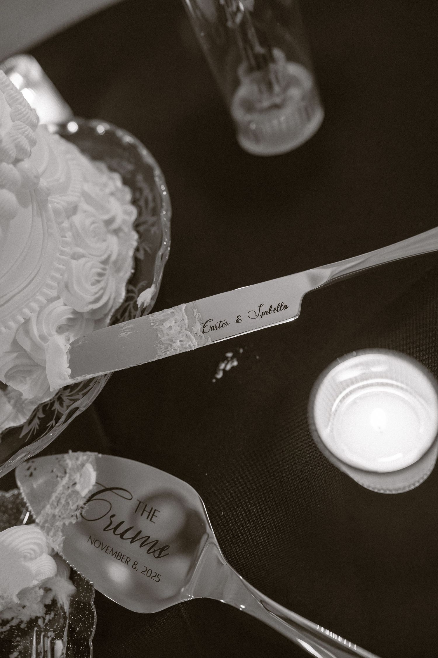 Black and white detail shot of wedding place cards on dark table with spotlighting.