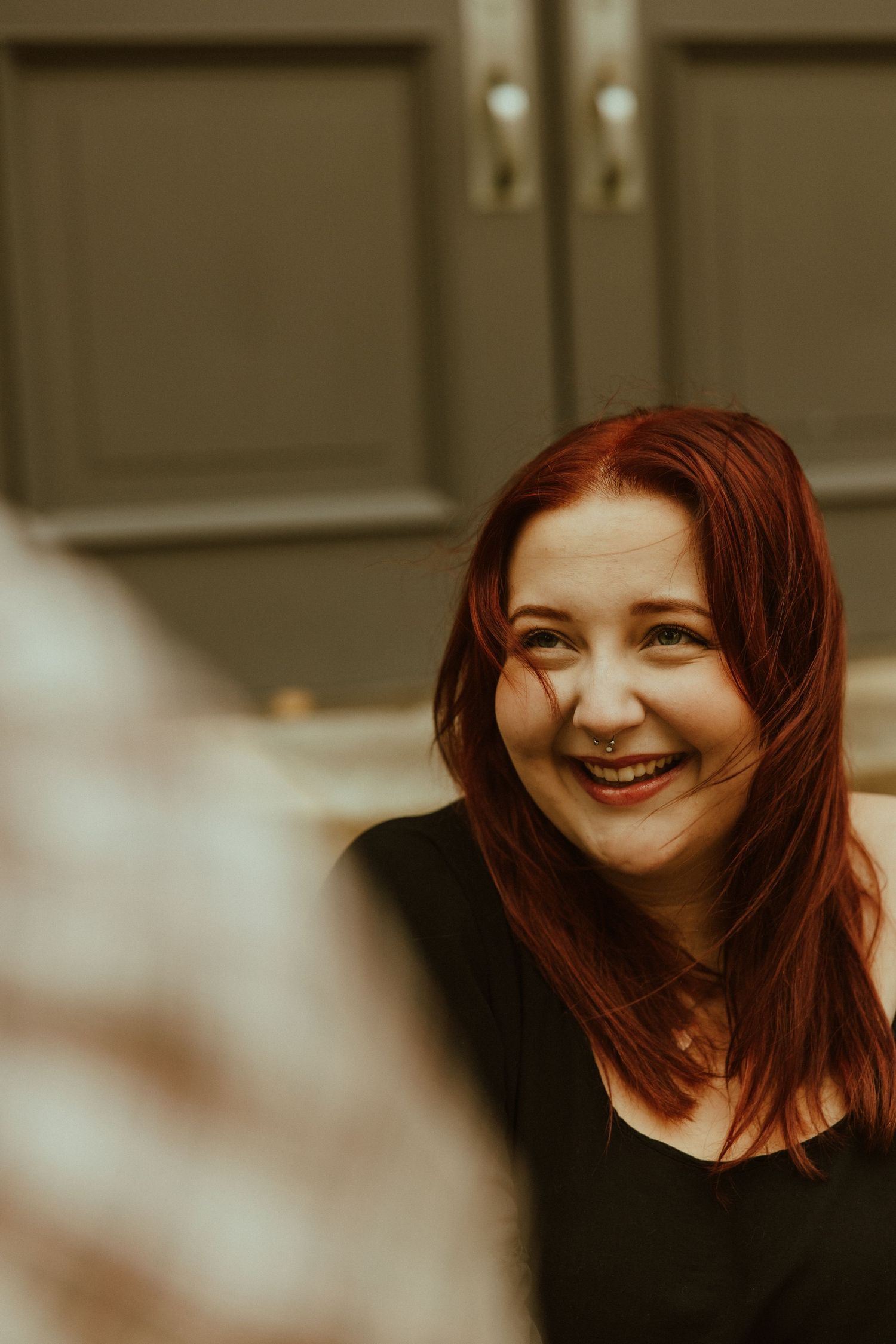 A series of five connected photos showing a person with red hair smiling and laughing in warm sepia tones.