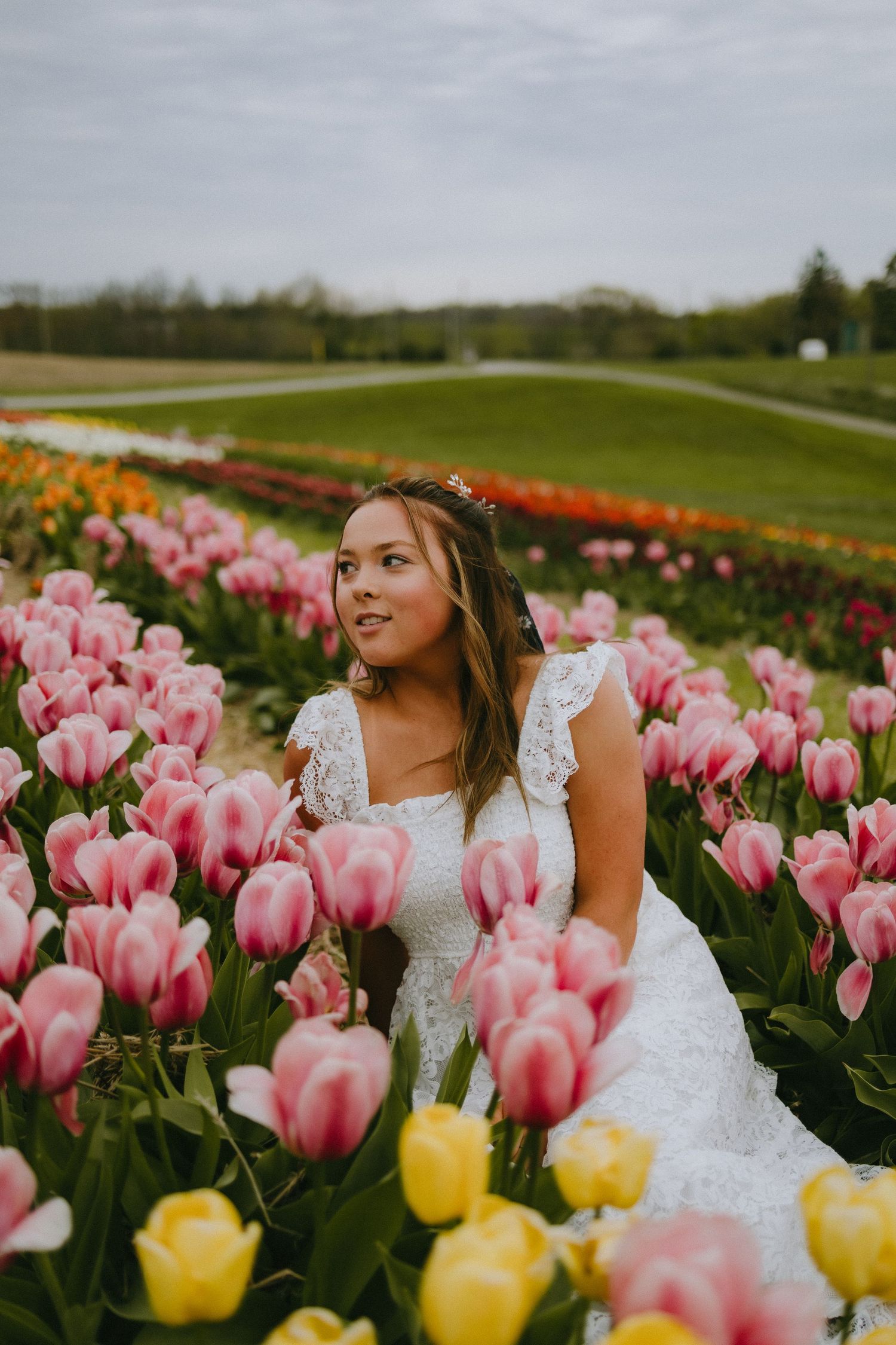 Wedding portrait surrounded by pink and yellow tulips in a spring garden.