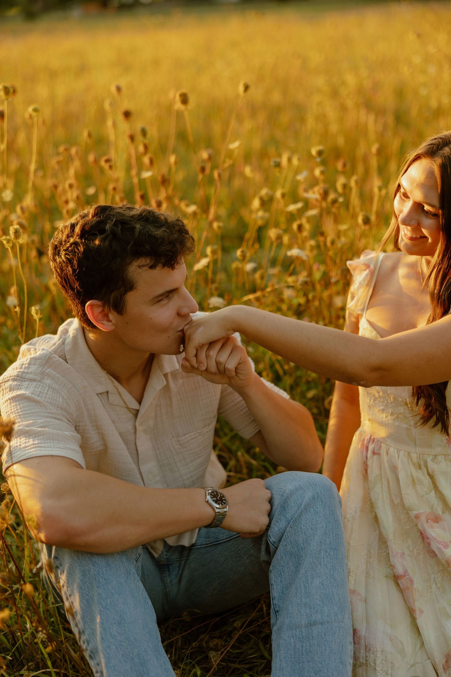 A romantic sunset moment between a couple in a golden wildflower field.