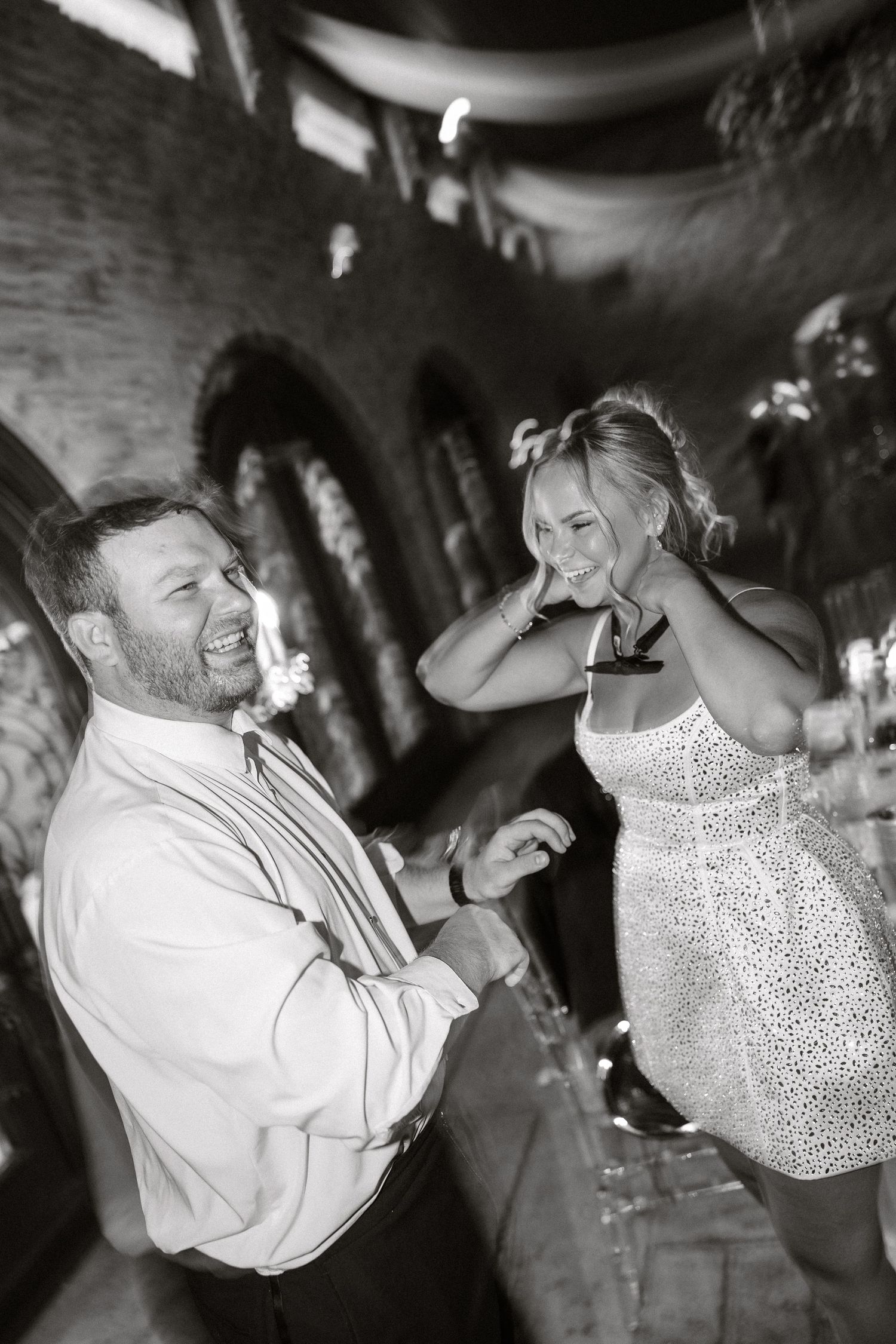 Black and white candid dance photos capturing joyful moments at a wedding reception.