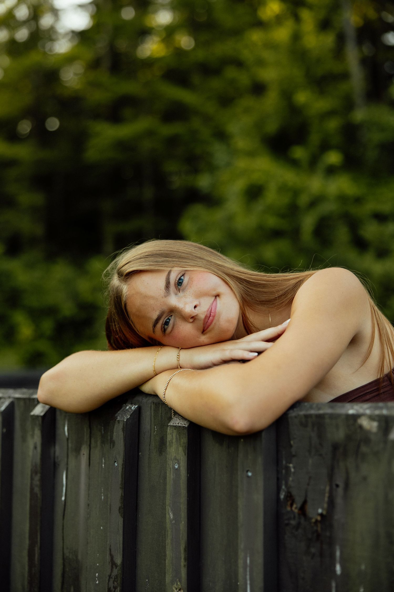 A serene portrait series showing someone resting their head on a wooden fence in a natural outdoor setting.