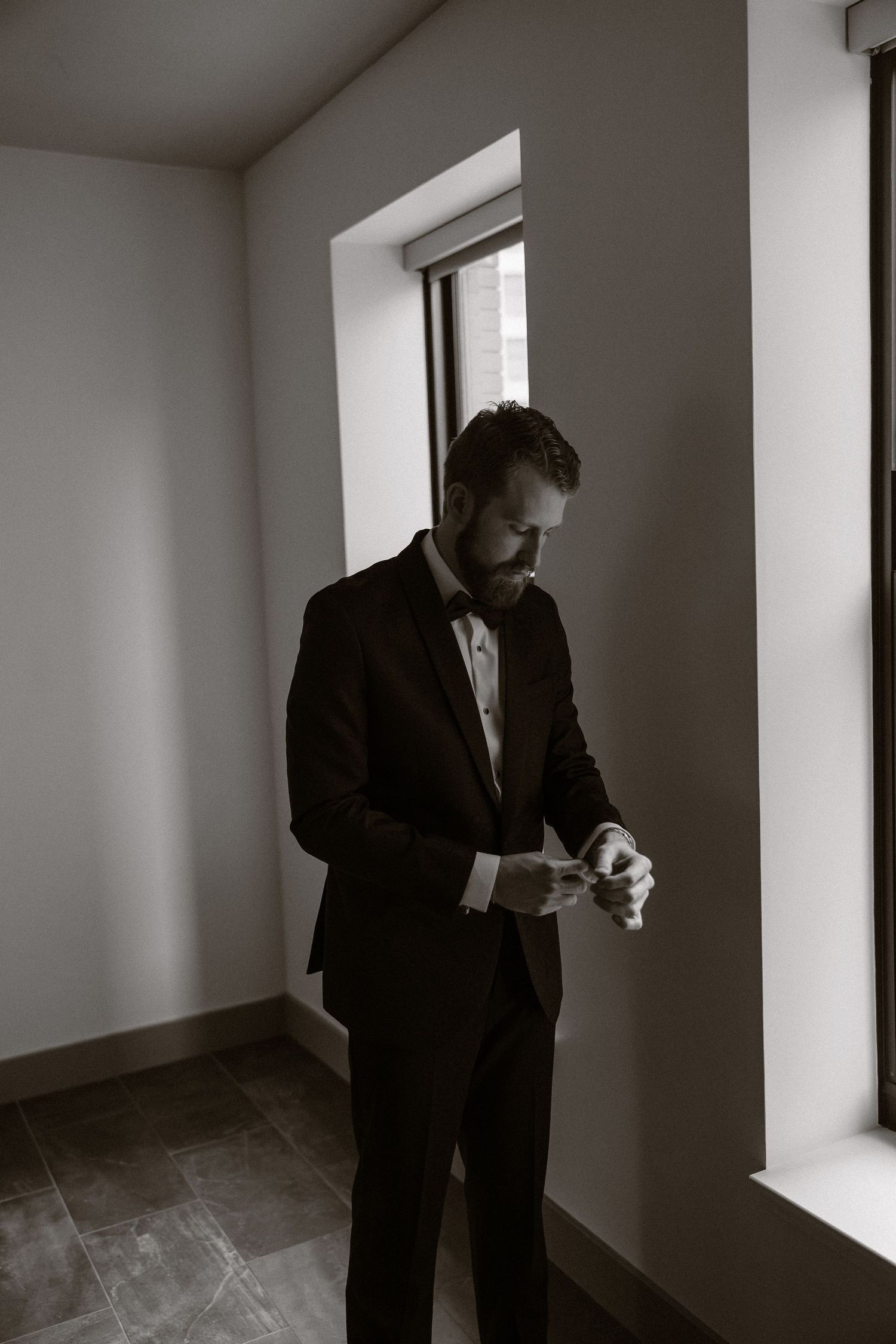 Black and white photo series showing a person in a suit standing near windows in an empty room.