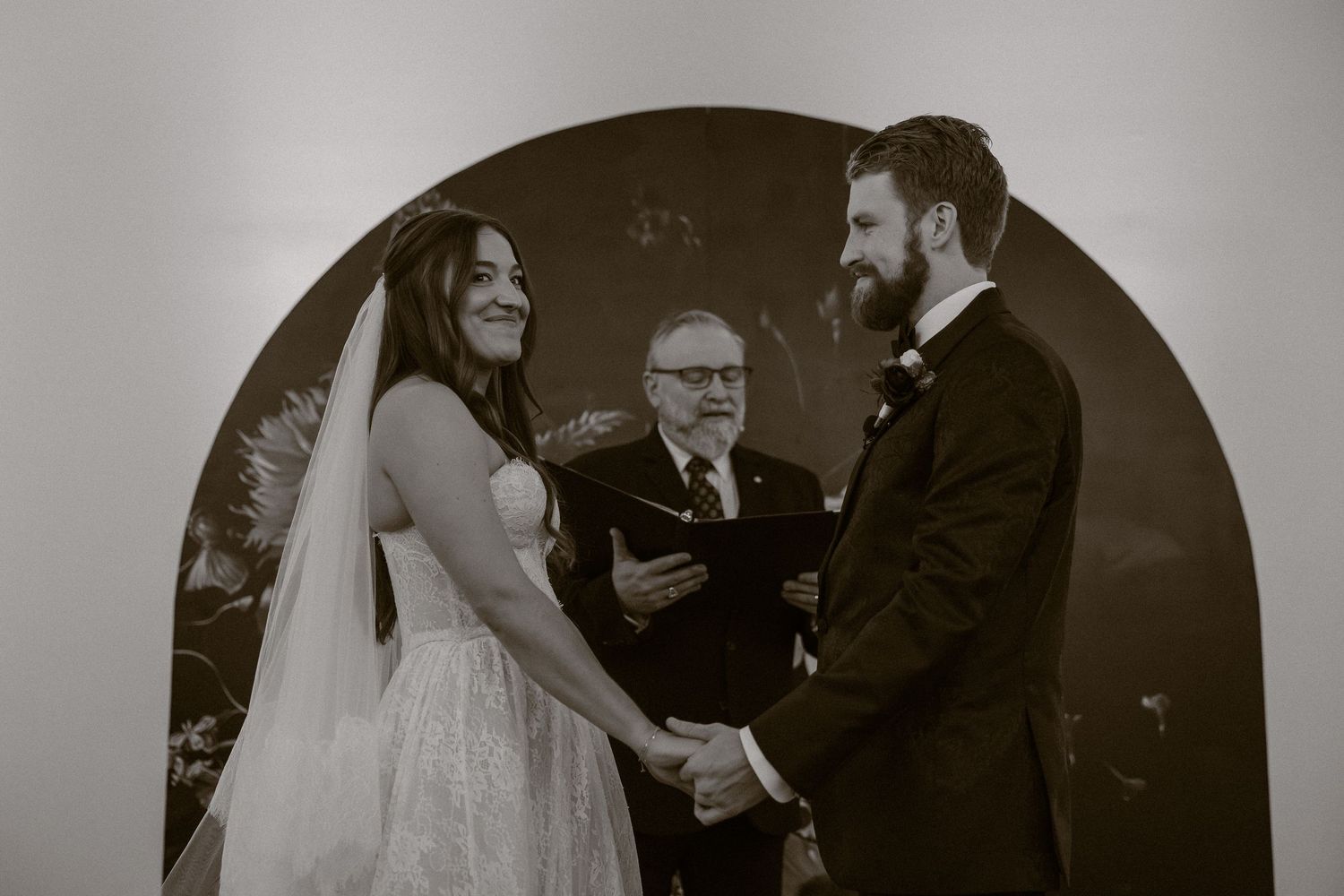 Black and white wedding ceremony photos showing emotional moments between bride and family members during traditional processional.