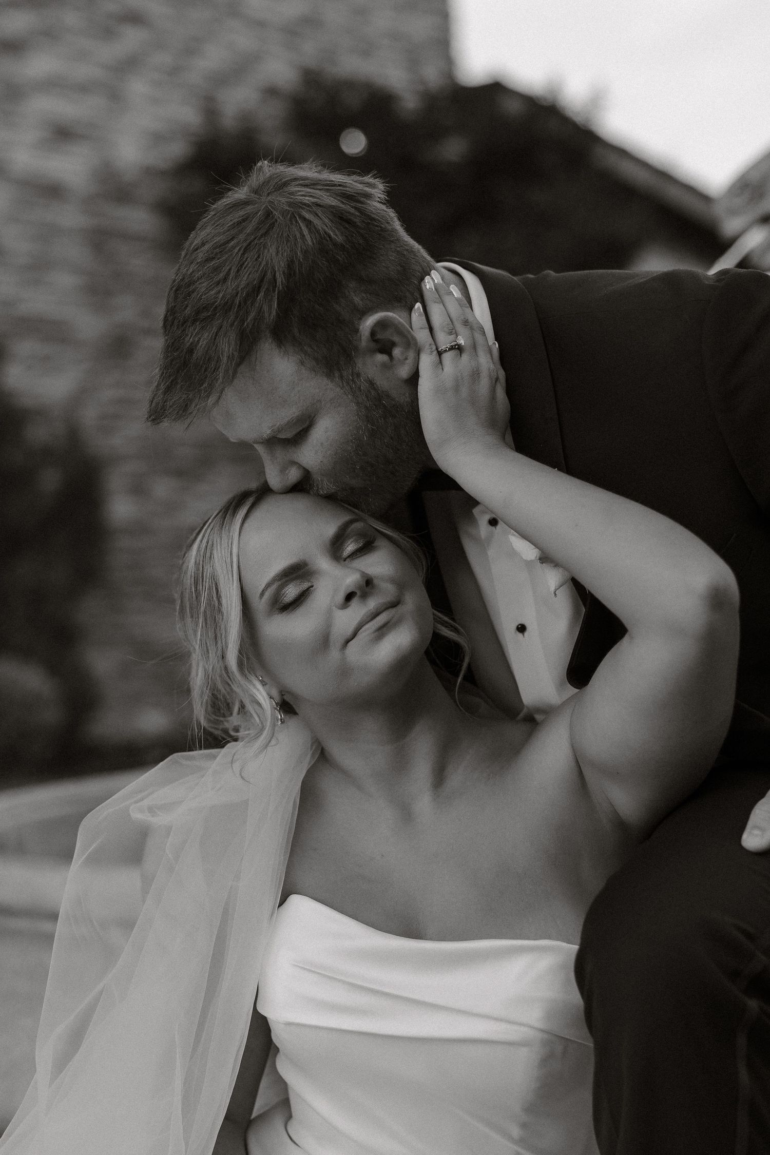 Artistic black and white close-up shots of newlyweds sharing tender moments during their wedding photoshoot.