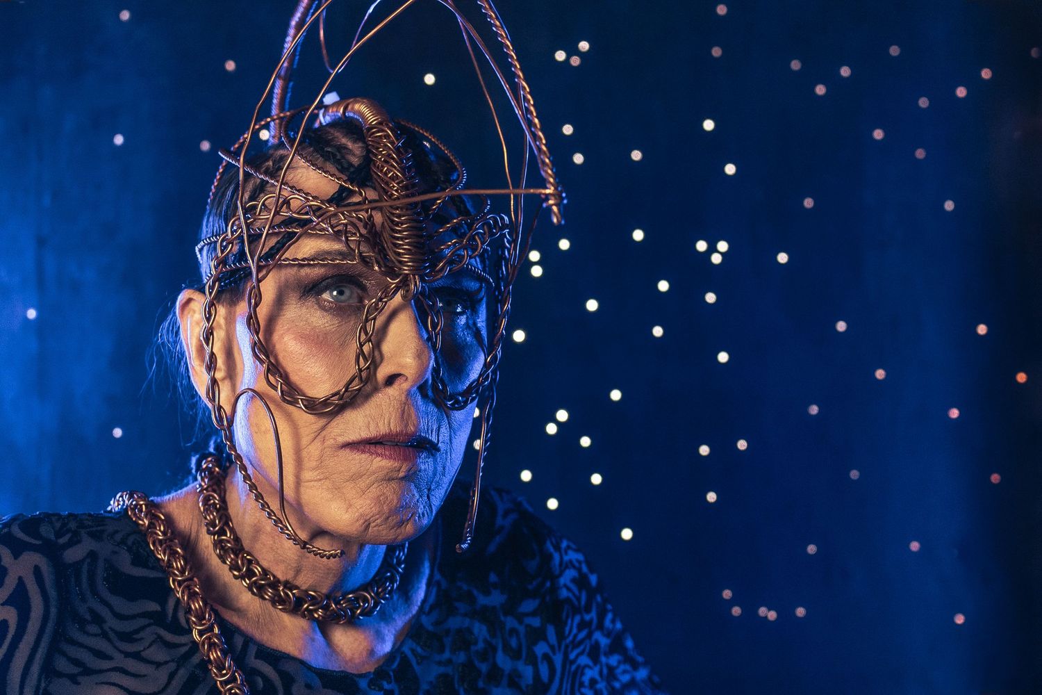 Artistic portrait with shimmering starlight and dramatic lighting showcasing art headpieces made by a local artist.