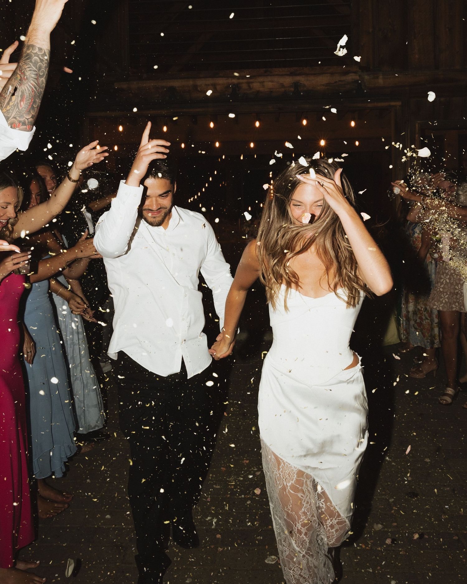 Wedding couple dancing and celebrating with confetti falling at their reception.