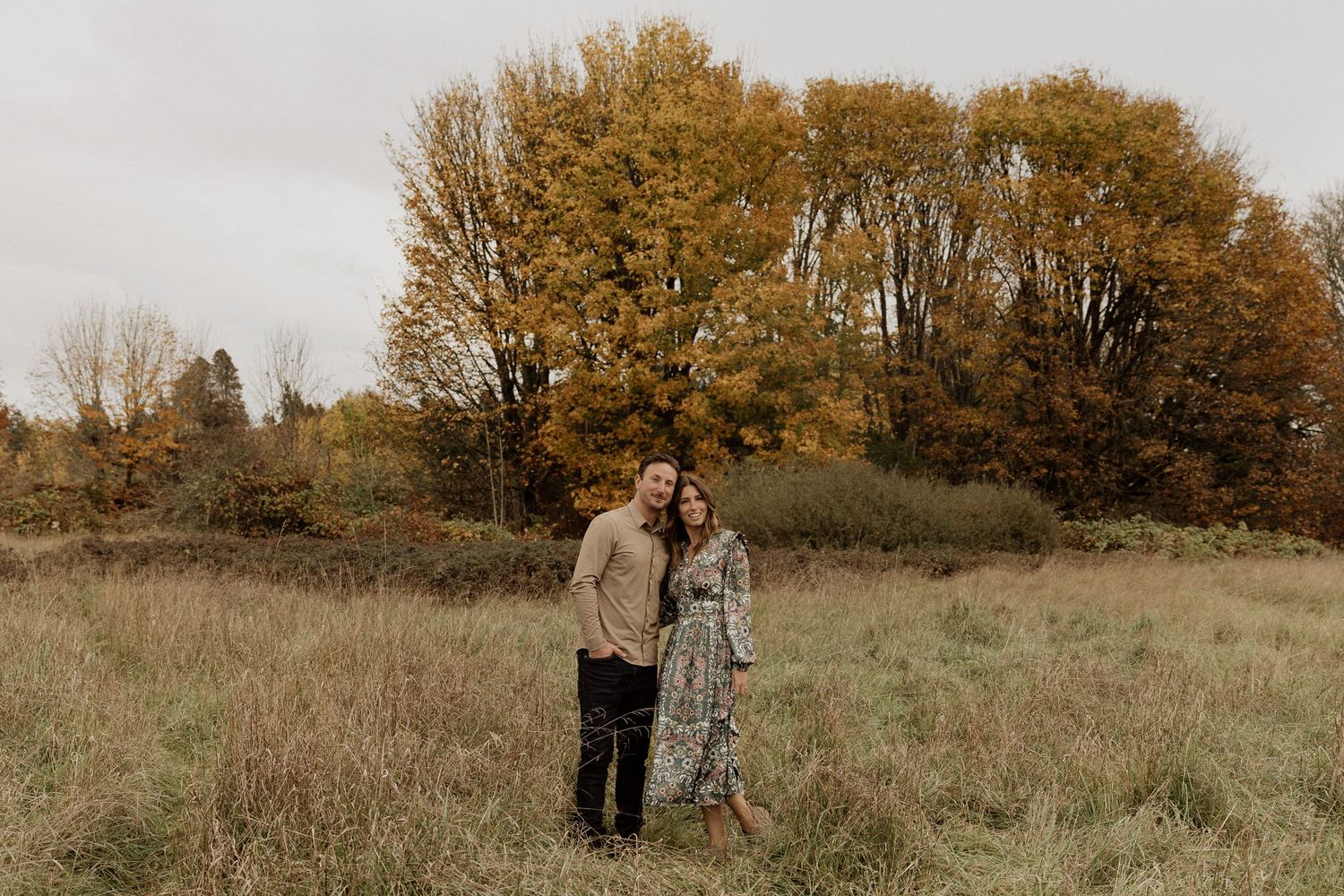 Intimate portrait in rustic fall field with golden trees in background.