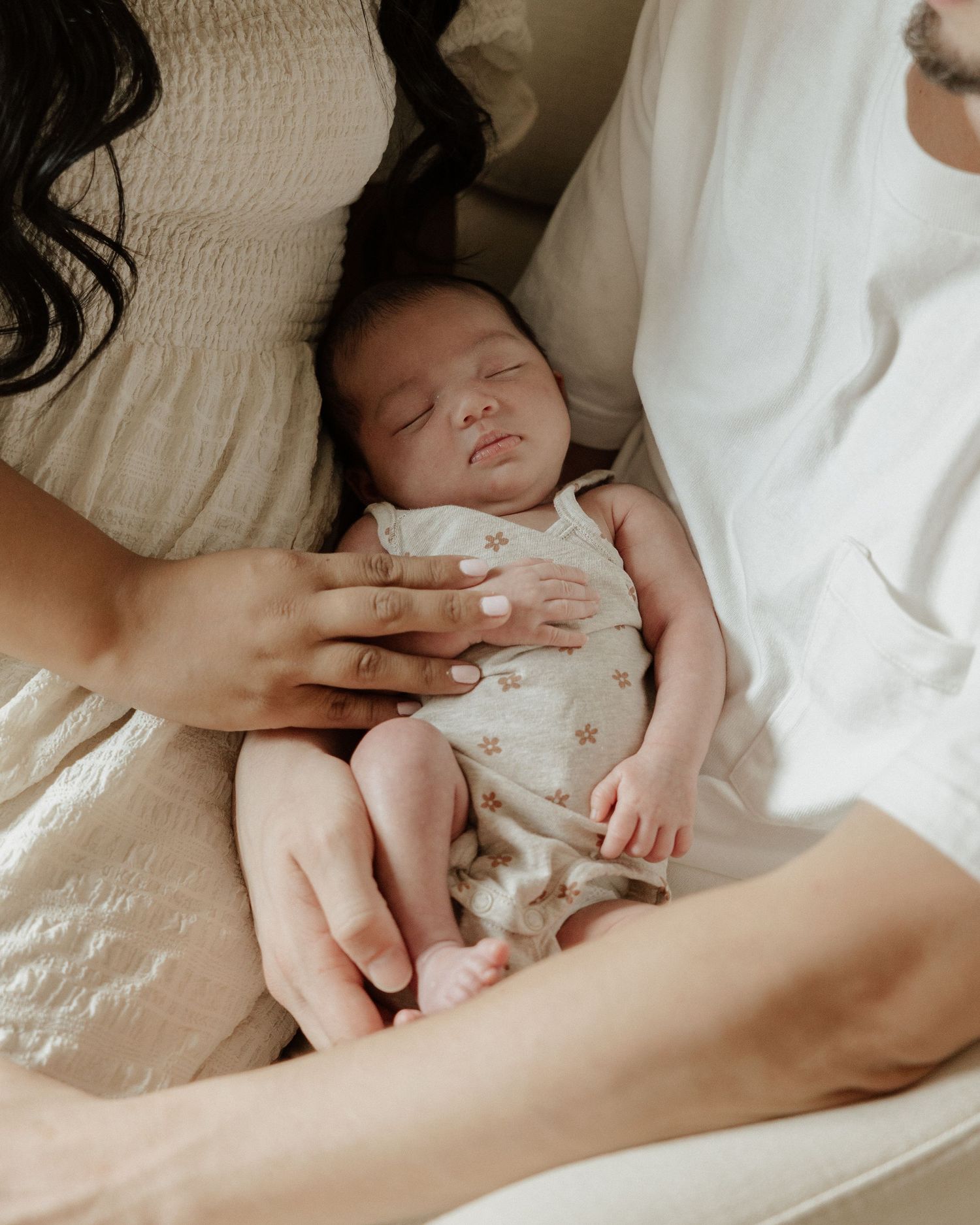 Sleeping newborn baby peacefully resting on white bedding.