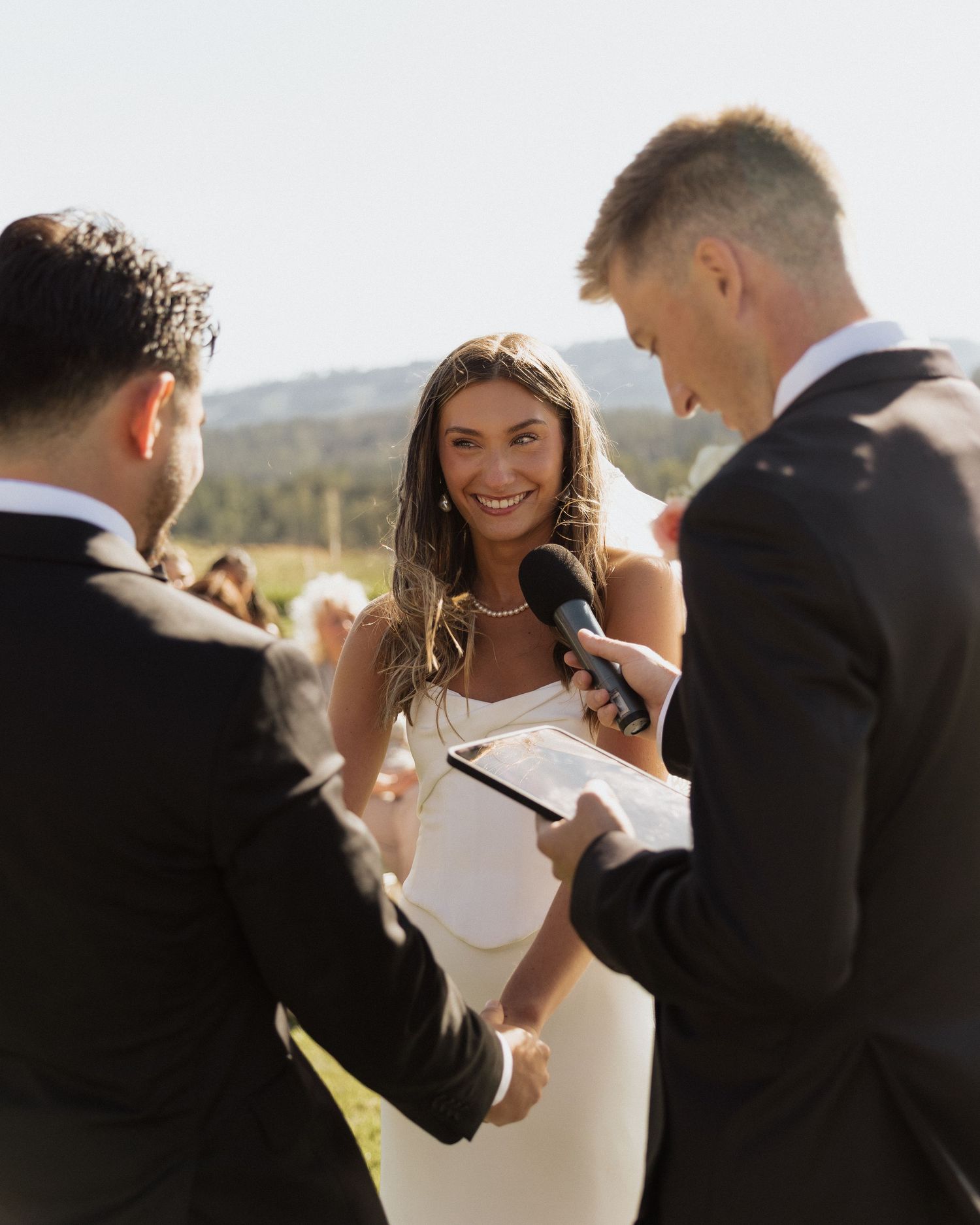 Joyful candid moments between a wedding couple and their wedding party in warm sunlight.