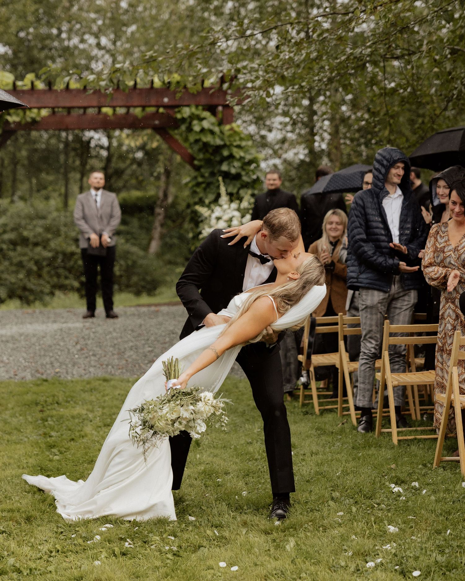 Dramatic dip pose during wedding ceremony with guests looking on.