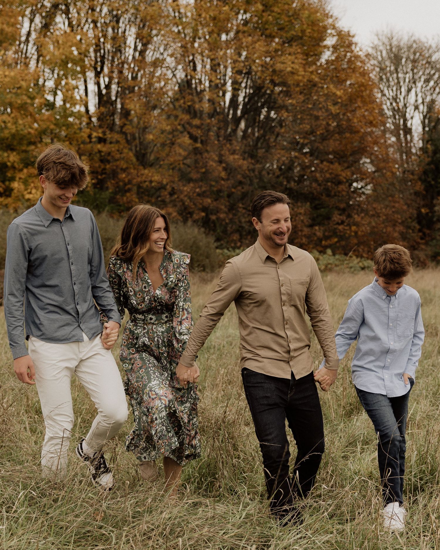 Group walking together through a fall meadow with golden trees in the background.