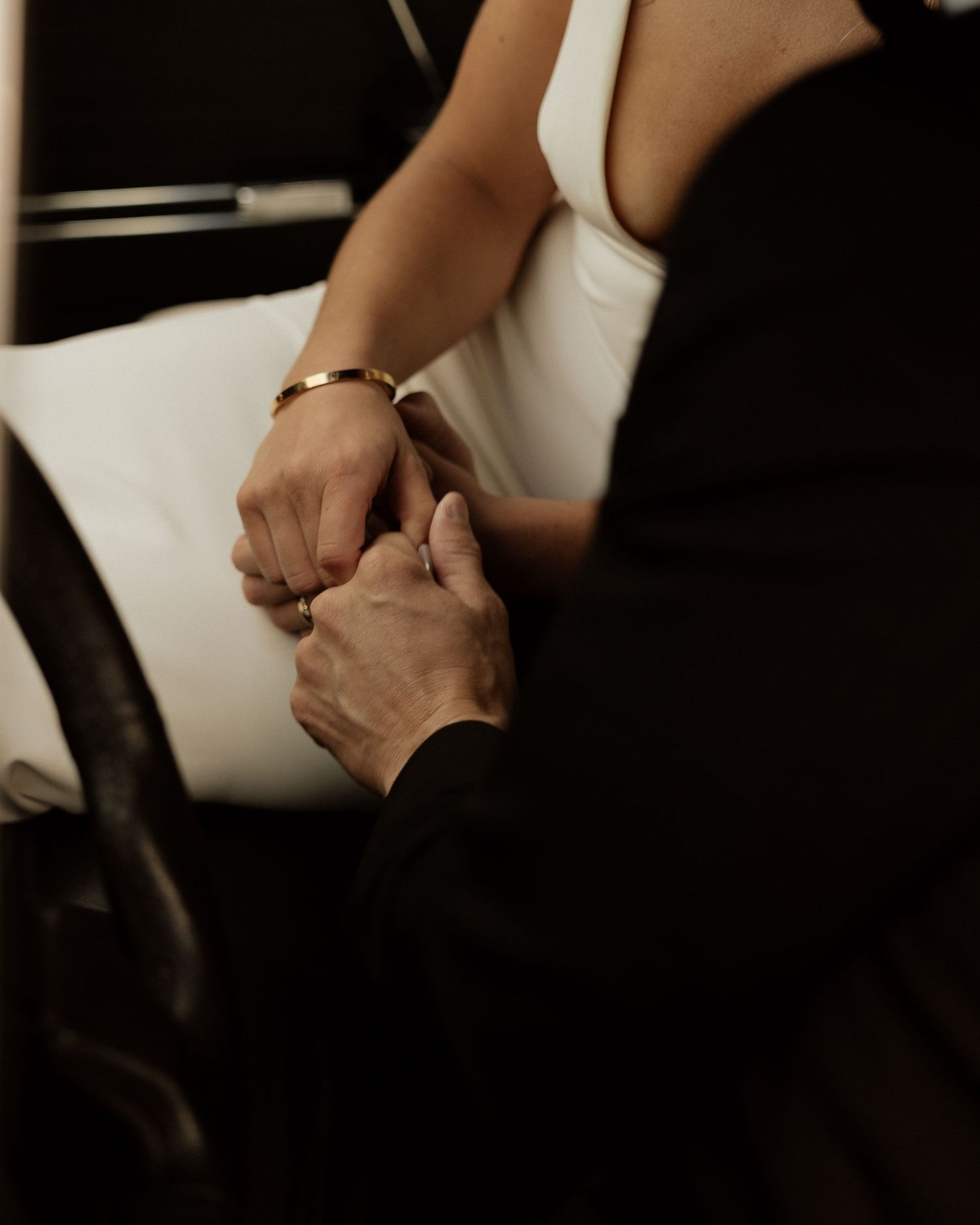 Intimate moment of couple holding hands during wedding ceremony.