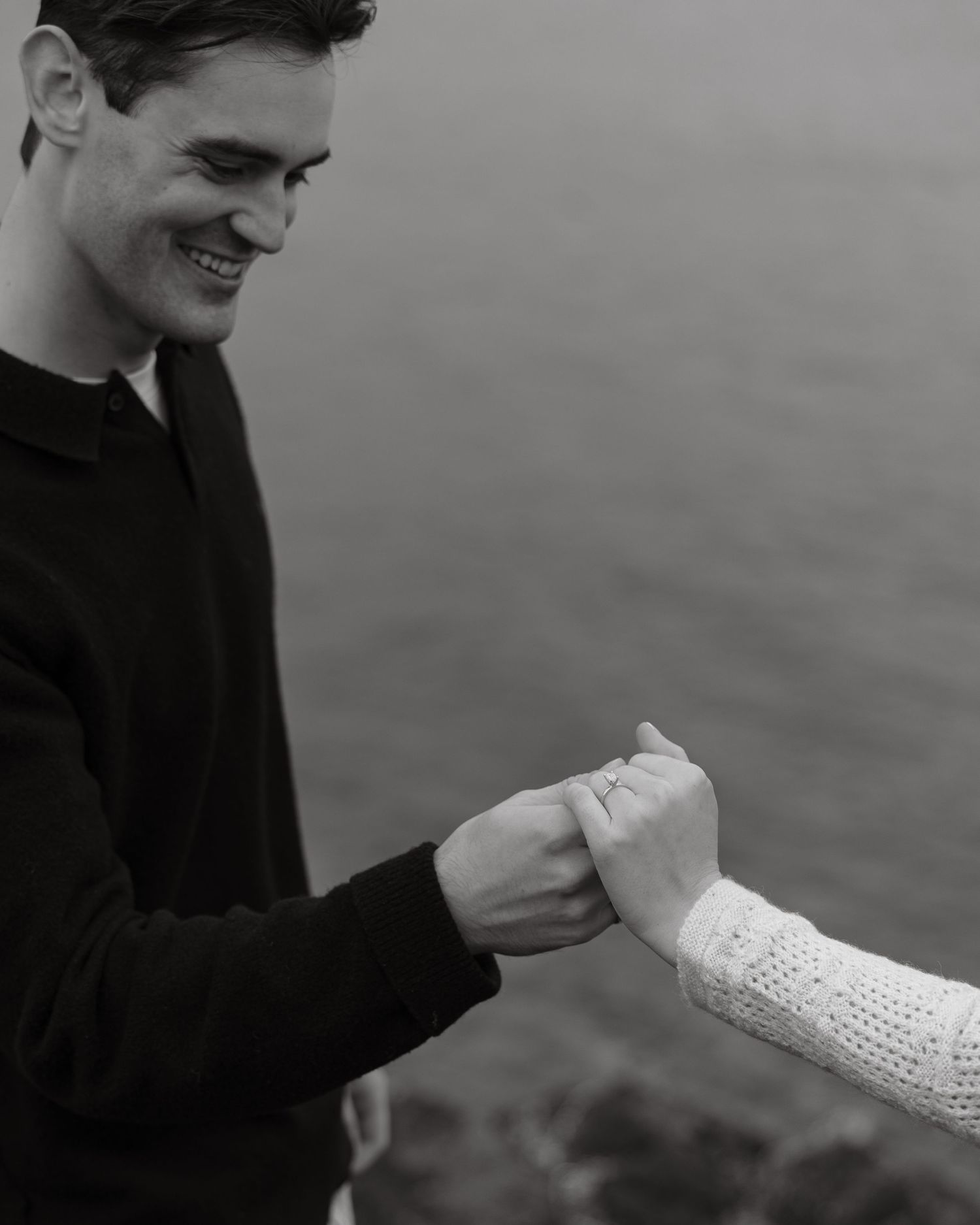 A joyful moment shared between two people holding hands by the water.
