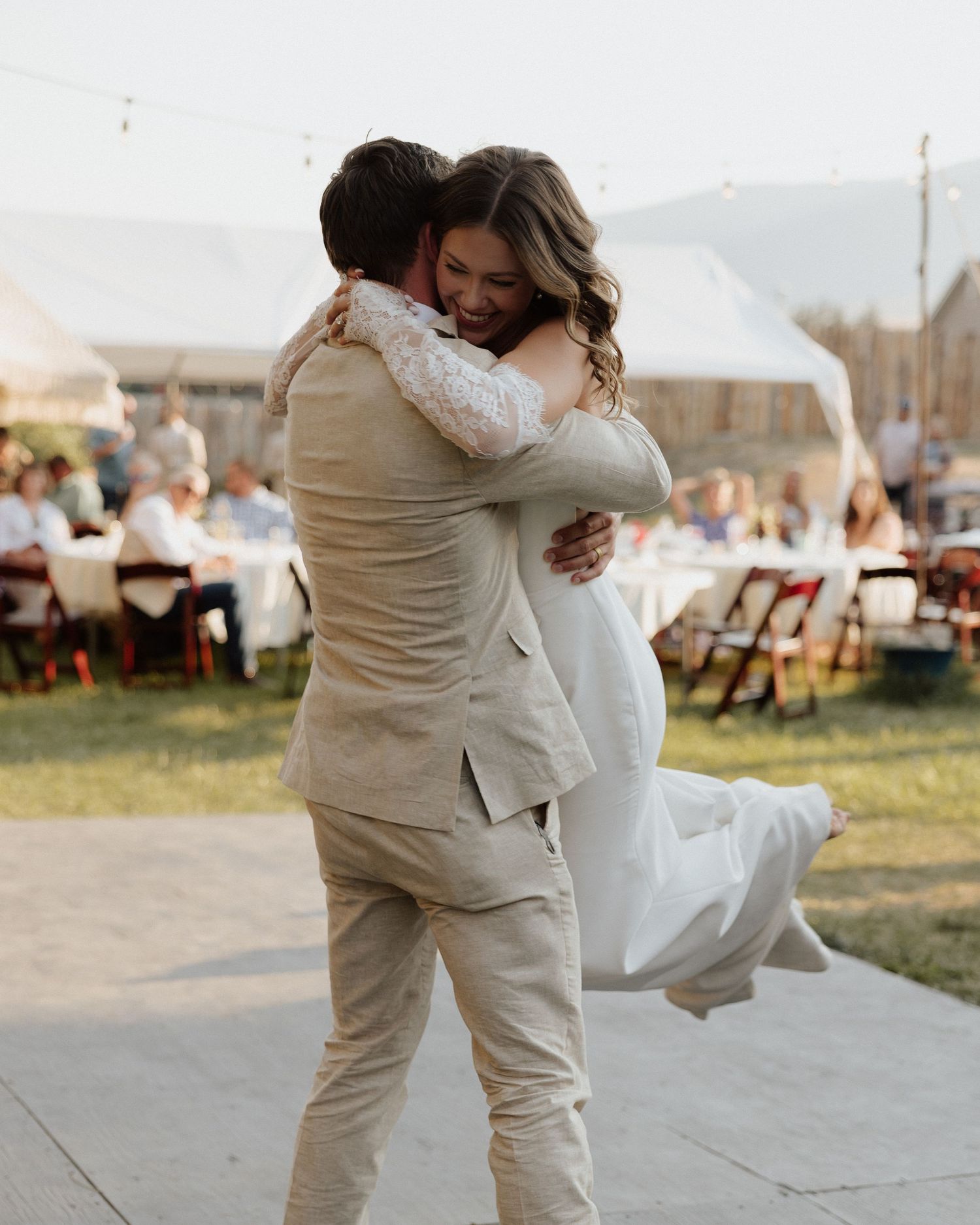 Newlyweds sharing a celebratory embrace on their wedding dance floor.
