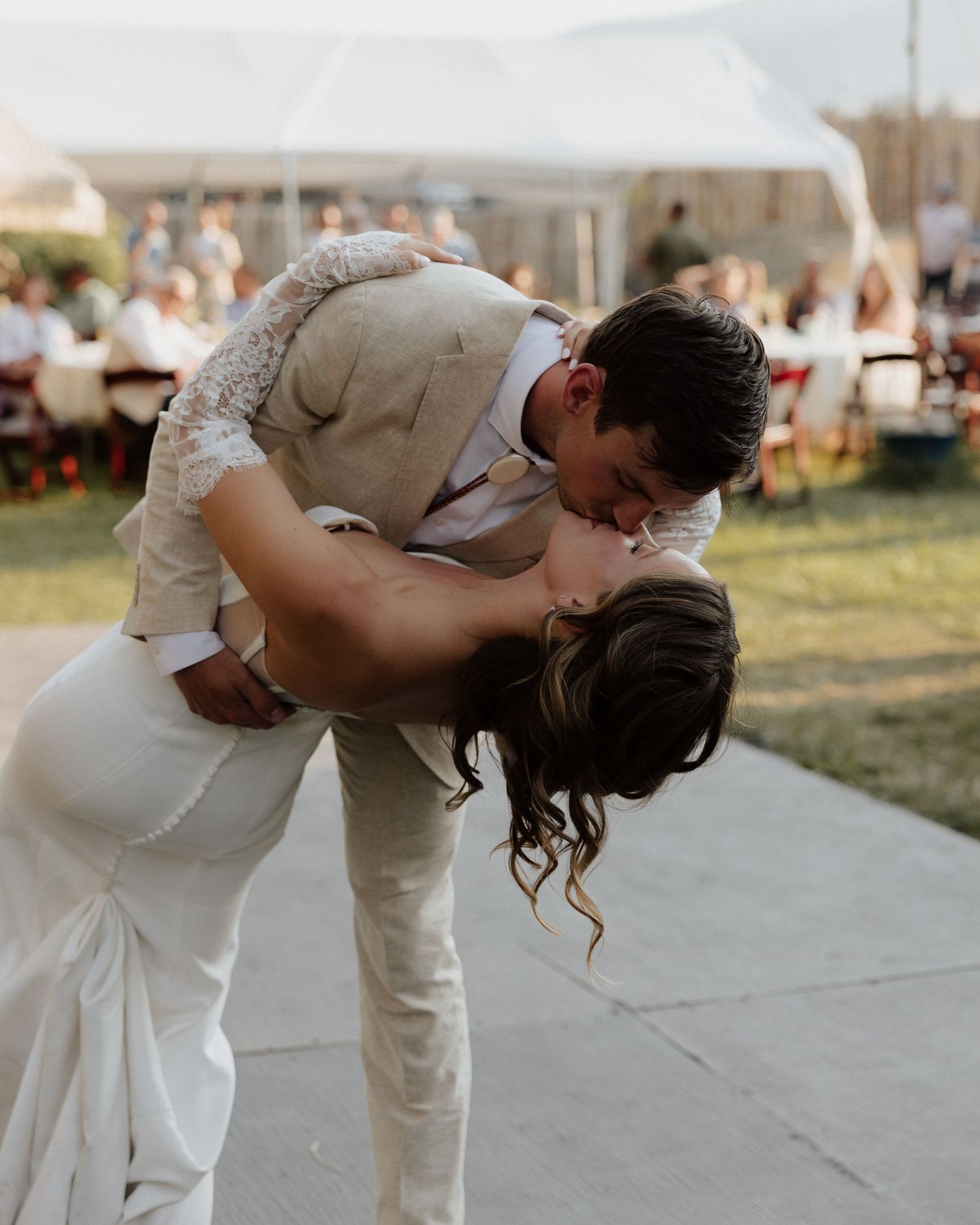 Romantic wedding dance dip captured during an outdoor reception.