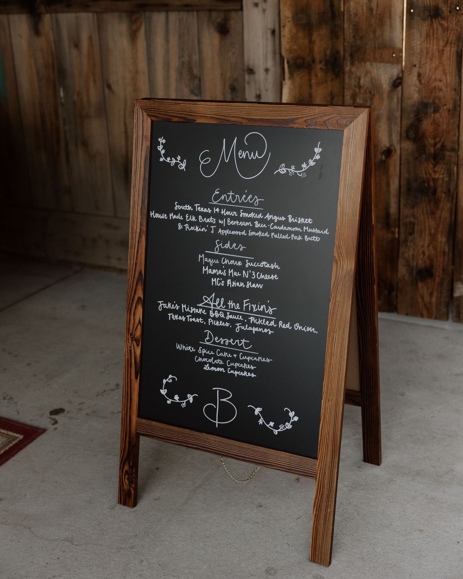 Rustic wooden framed chalkboard displaying an elegant wedding menu.