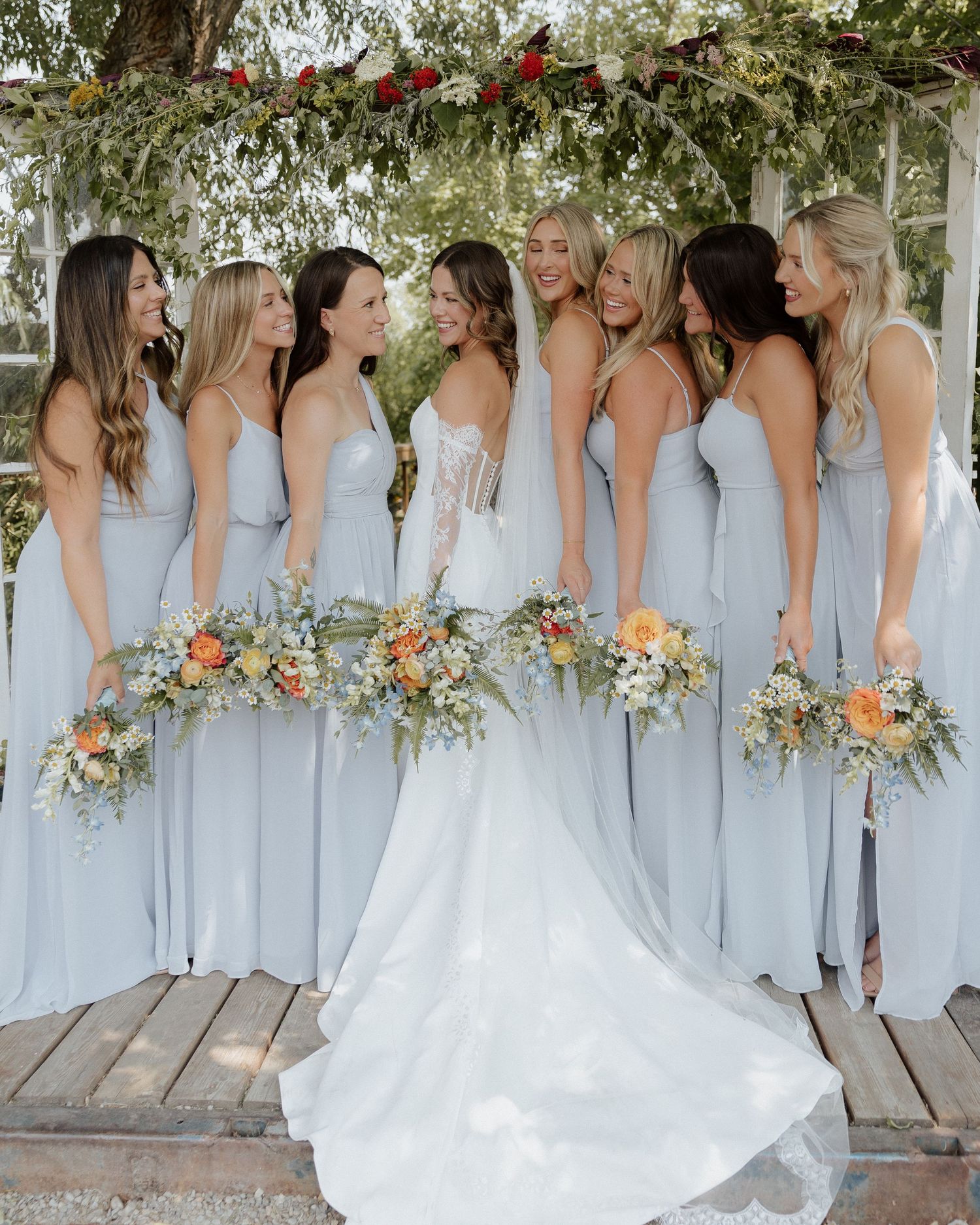 Side view of bridesmaids in light blue dresses with bride in white wedding gown.