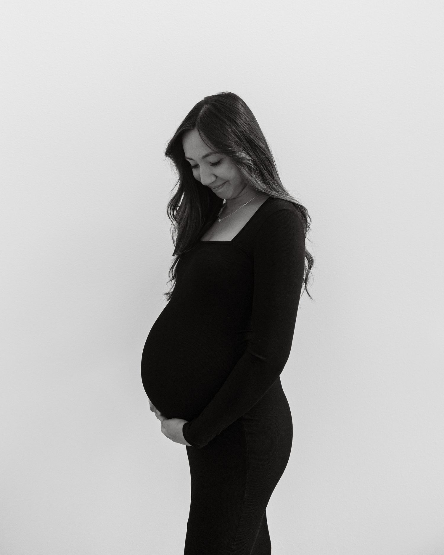A minimalist black and white maternity photo against a white background.