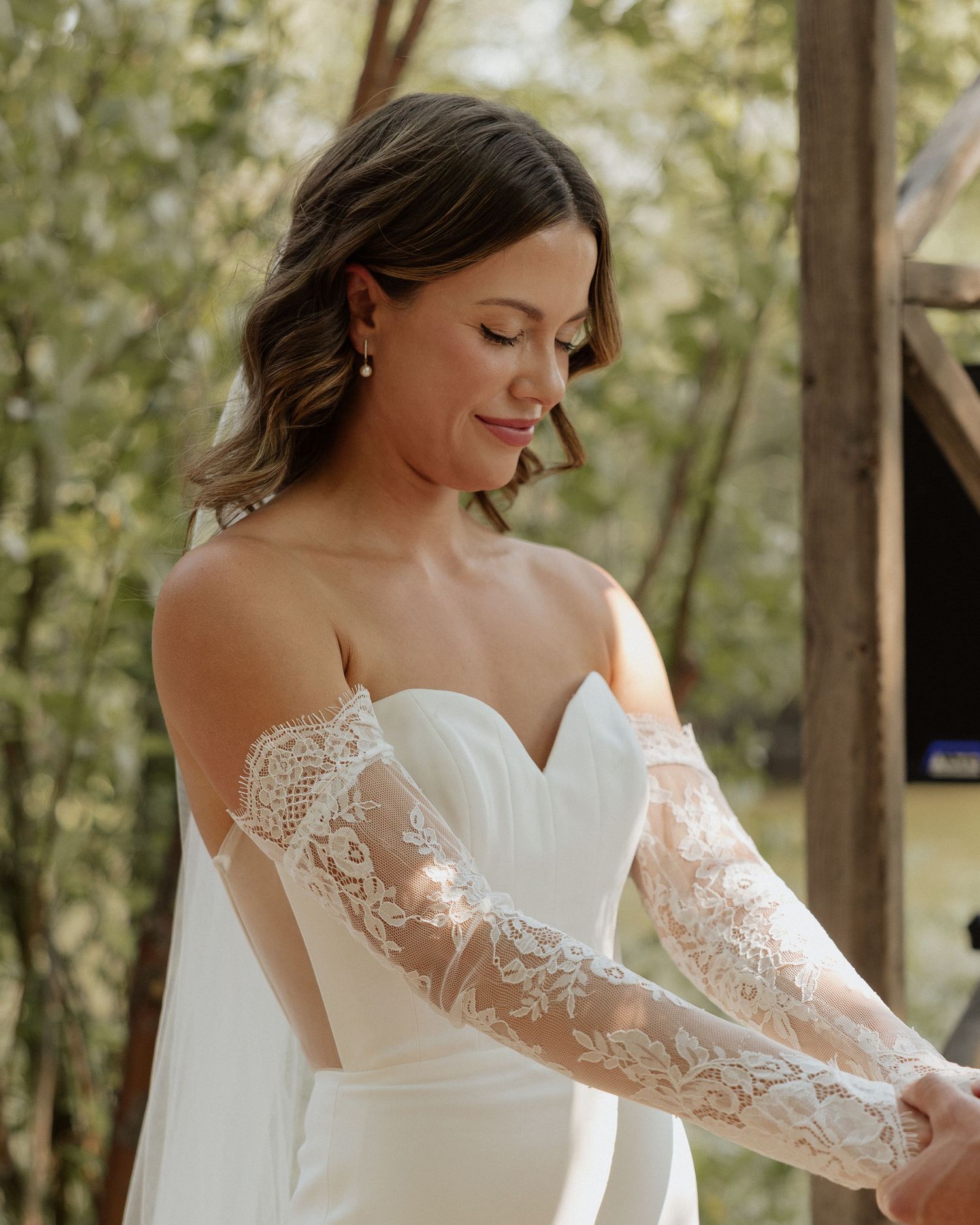 Close-up of detailed lace sleeve on white wedding dress.