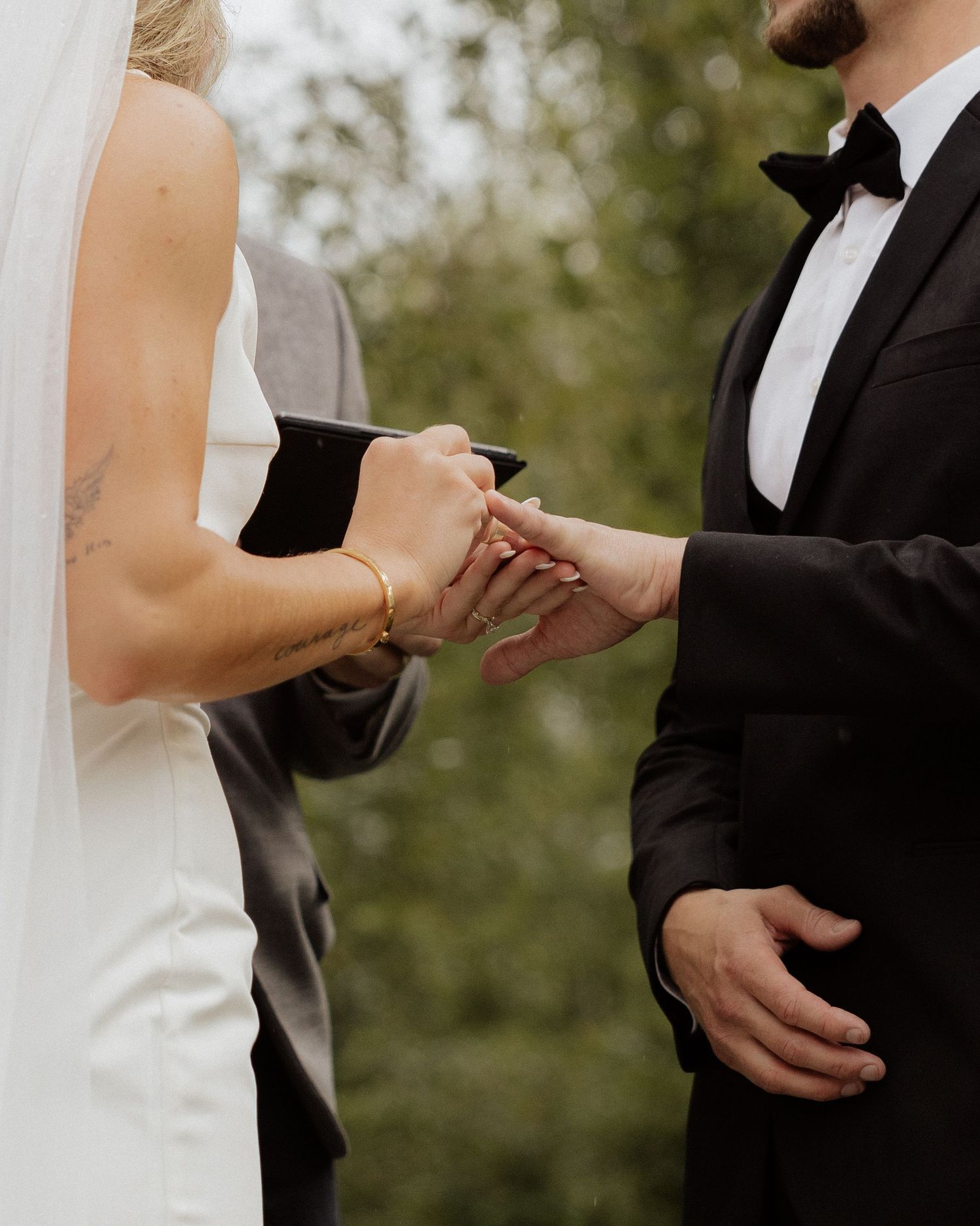 Close up of wedding couple's hands during ring exchange ceremony.