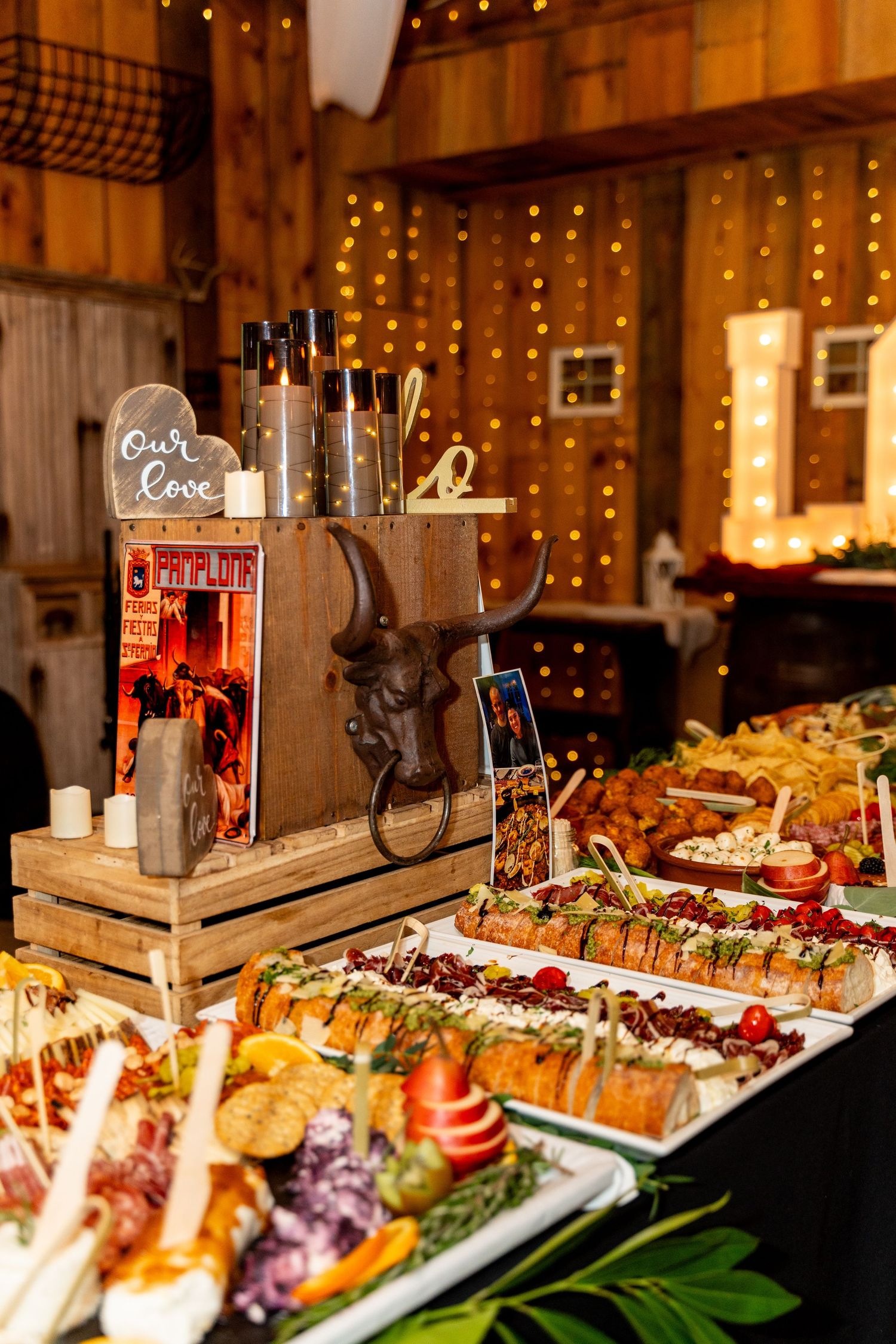 Rustic wedding reception buffet with string lights and wooden decor.