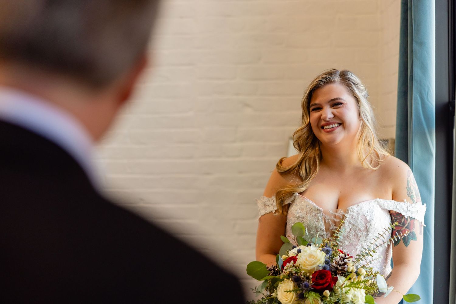 Candid moment during wedding first look with bouquet in hand.