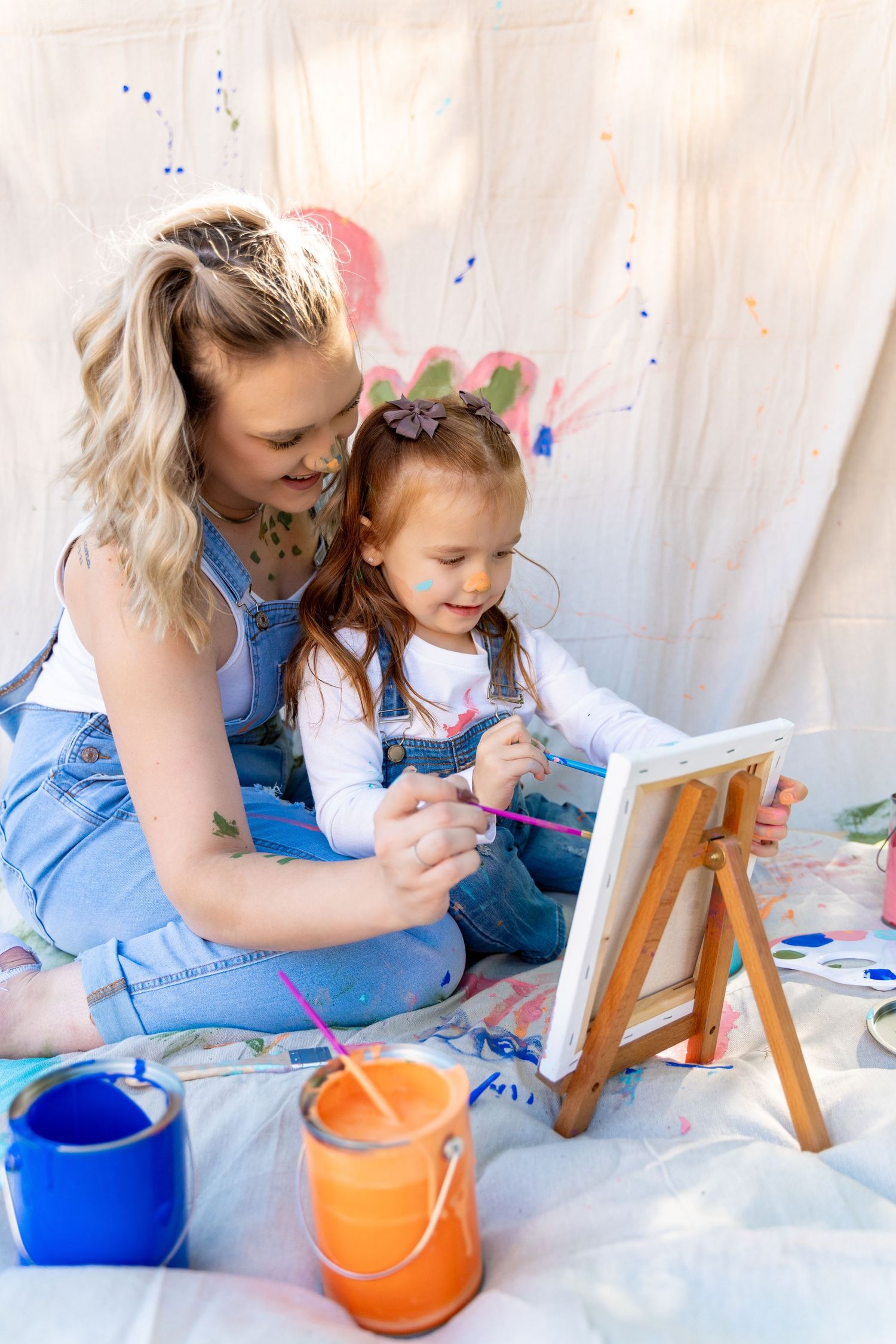 A creative painting session with matching denim outfits and colorful paint pots.