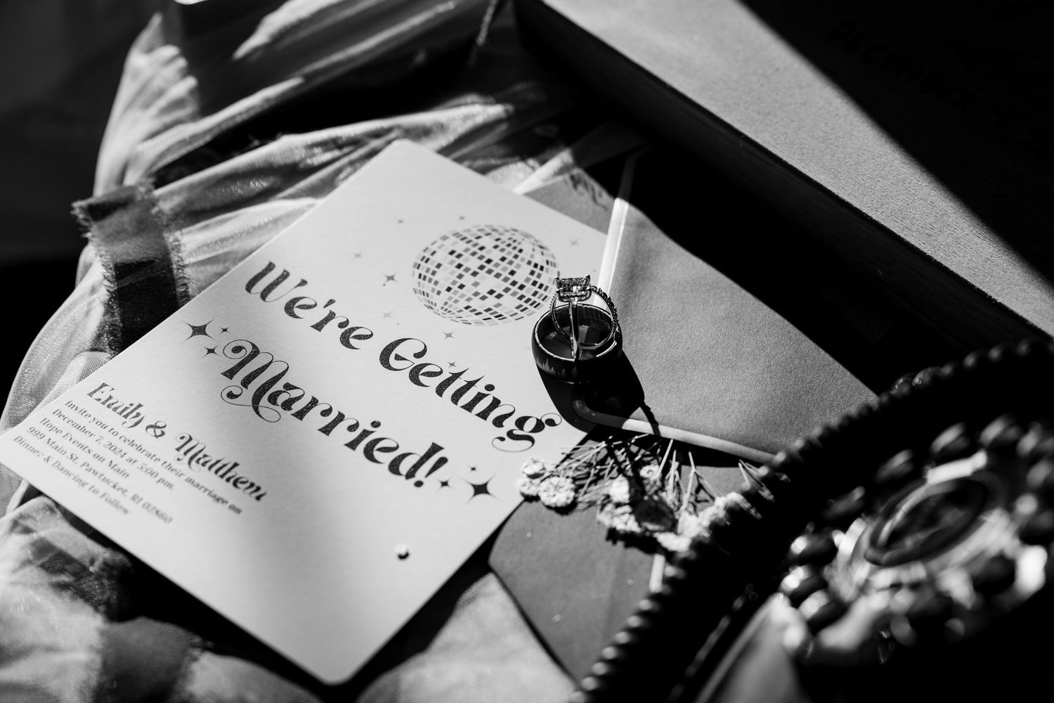Wedding invitation and rings arranged artistically in black and white.